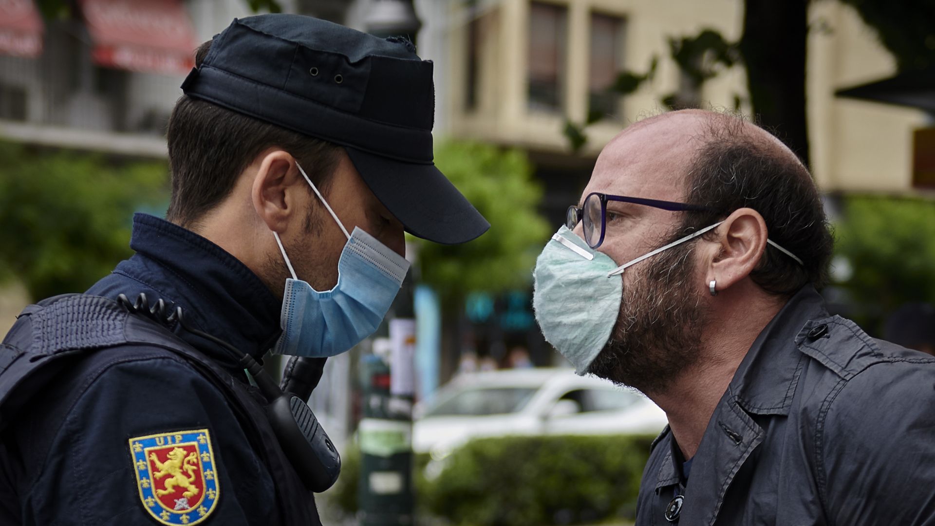 In this image, a masked man confronts a masked police officer