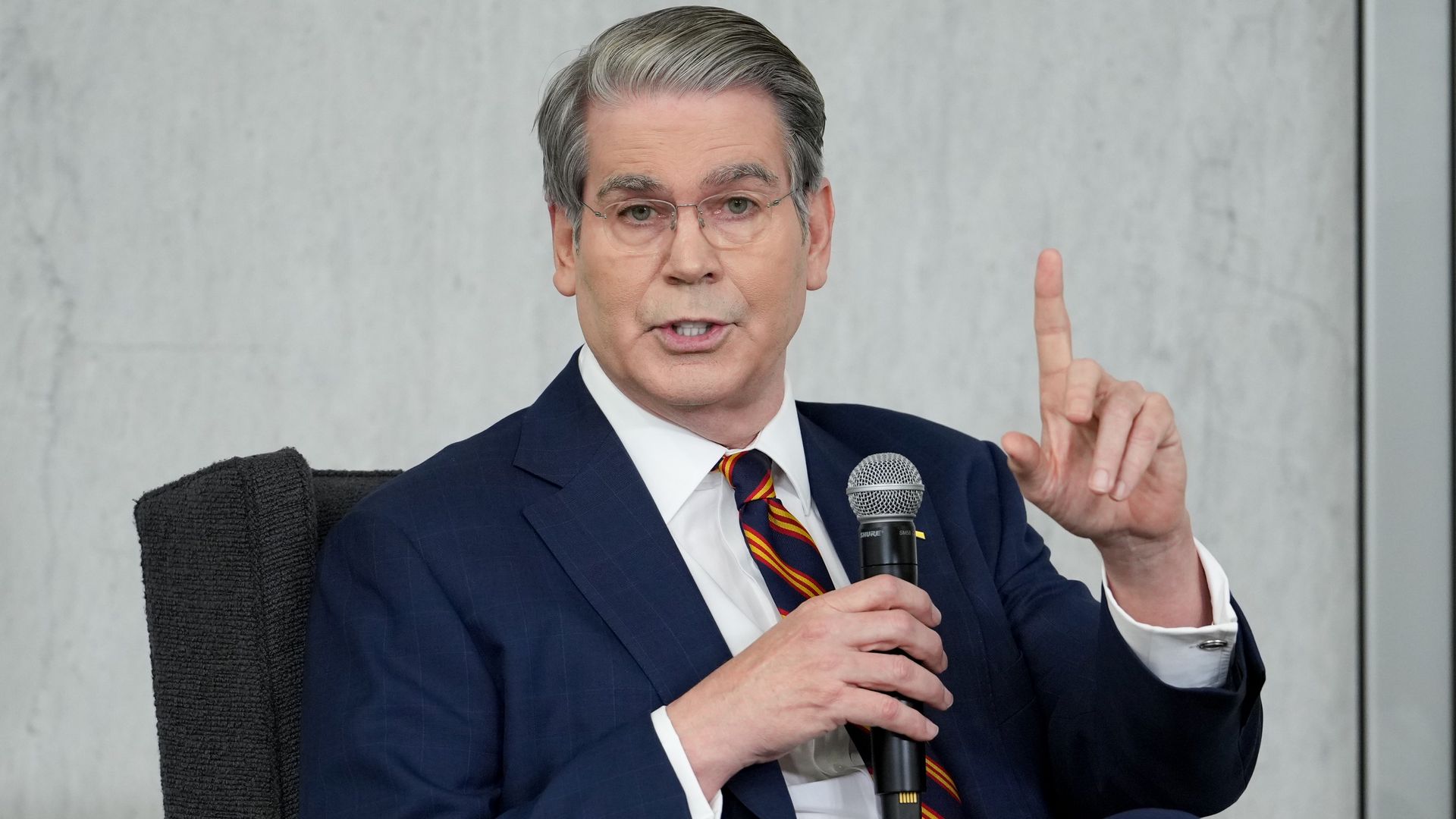 Treasury Secretary Scott Bessent sitting and pointing up.