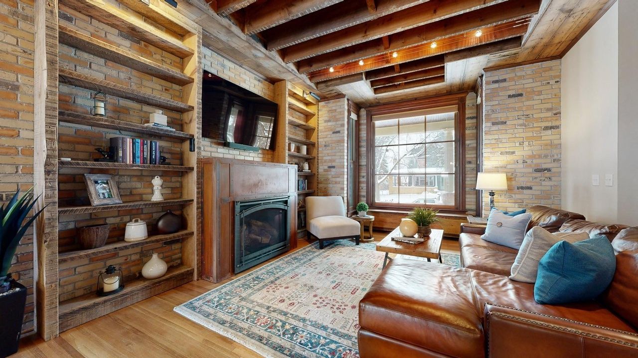 family room with exposed brick and wood beams throughout
