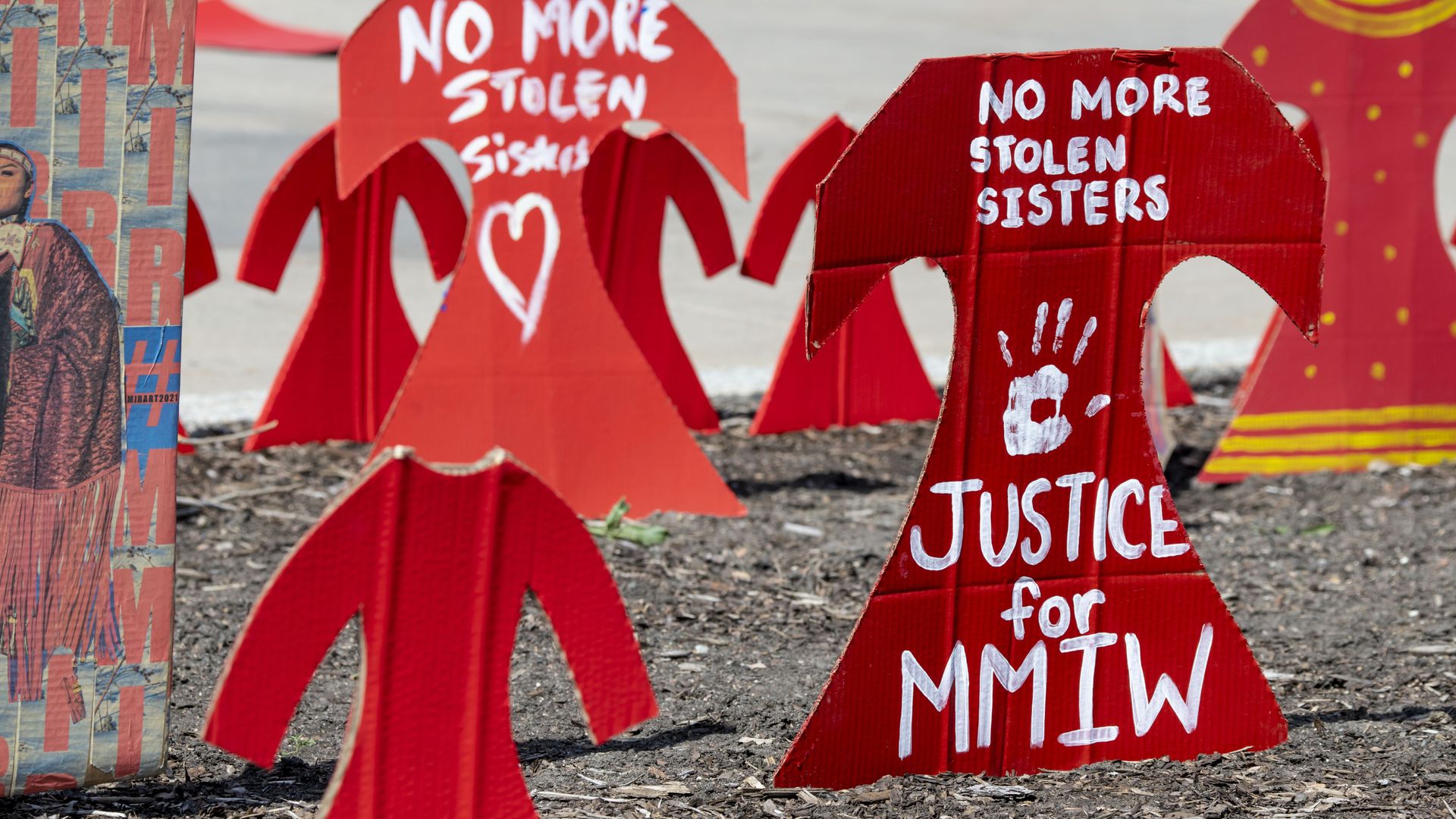 Photo of red signs that say "No more stolen sisters, justice for MMIW"