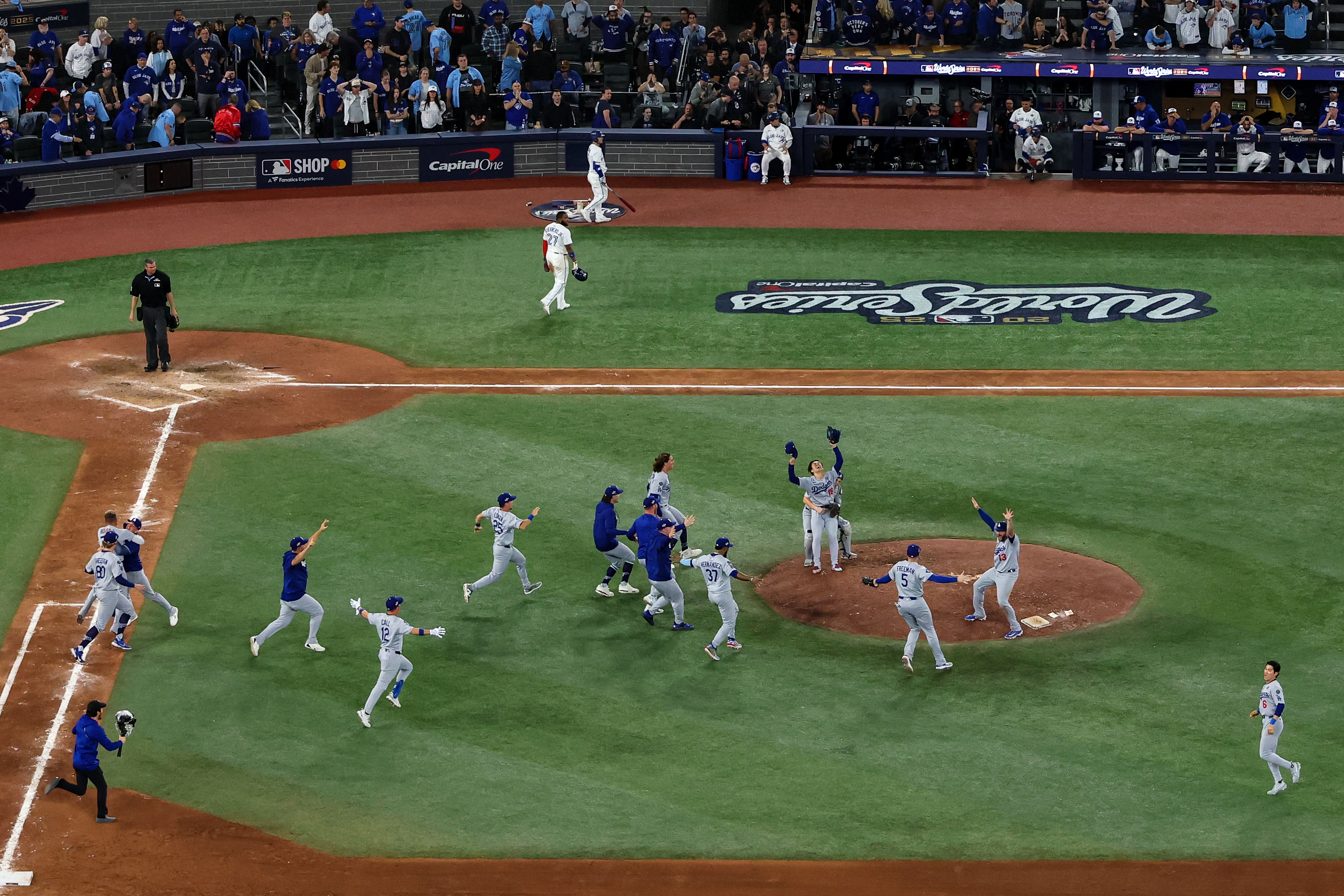 : Pitcher Yoshinobu Yamamoto #18 of the Los Angeles Dodgers (R) celebrates with teammates after defeating the Toronto Blue Jays, 5-4, in game seven of the 2025 World Series at Rogers Center on November 02, 2025 in Toronto, Ontario. (Photo by Patrick Smith/Getty Images)