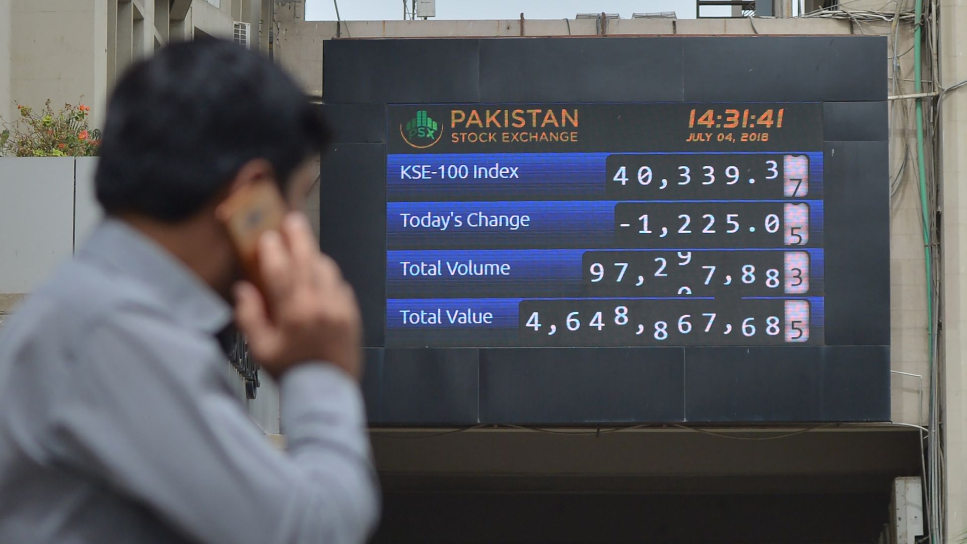 A Pakistani stockbroker looks at an index board during a trading session at the Pakistan Stock Exchange