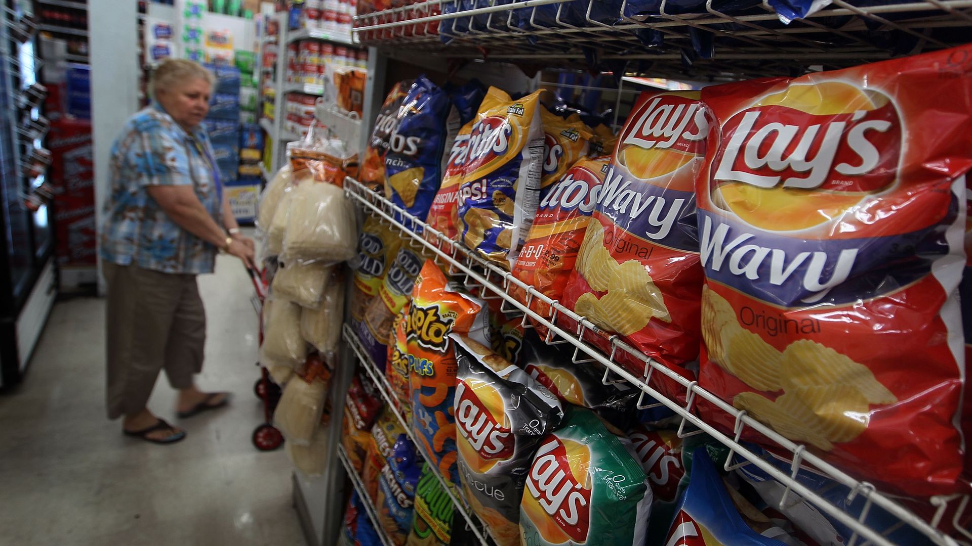 A shopper looking at a wall of snacks.