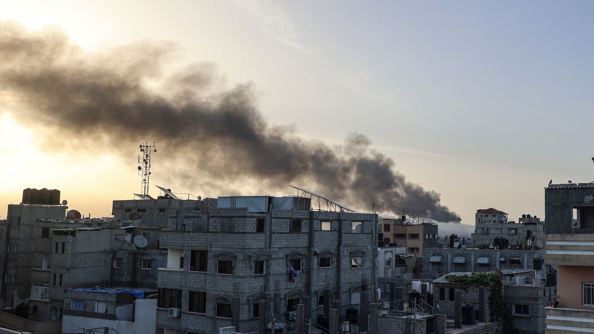 Smoke rises above building at sunrise, in the aftermath of Israeli bombardment in Rafah in the southern Gaza Strip on May 10, 2024,