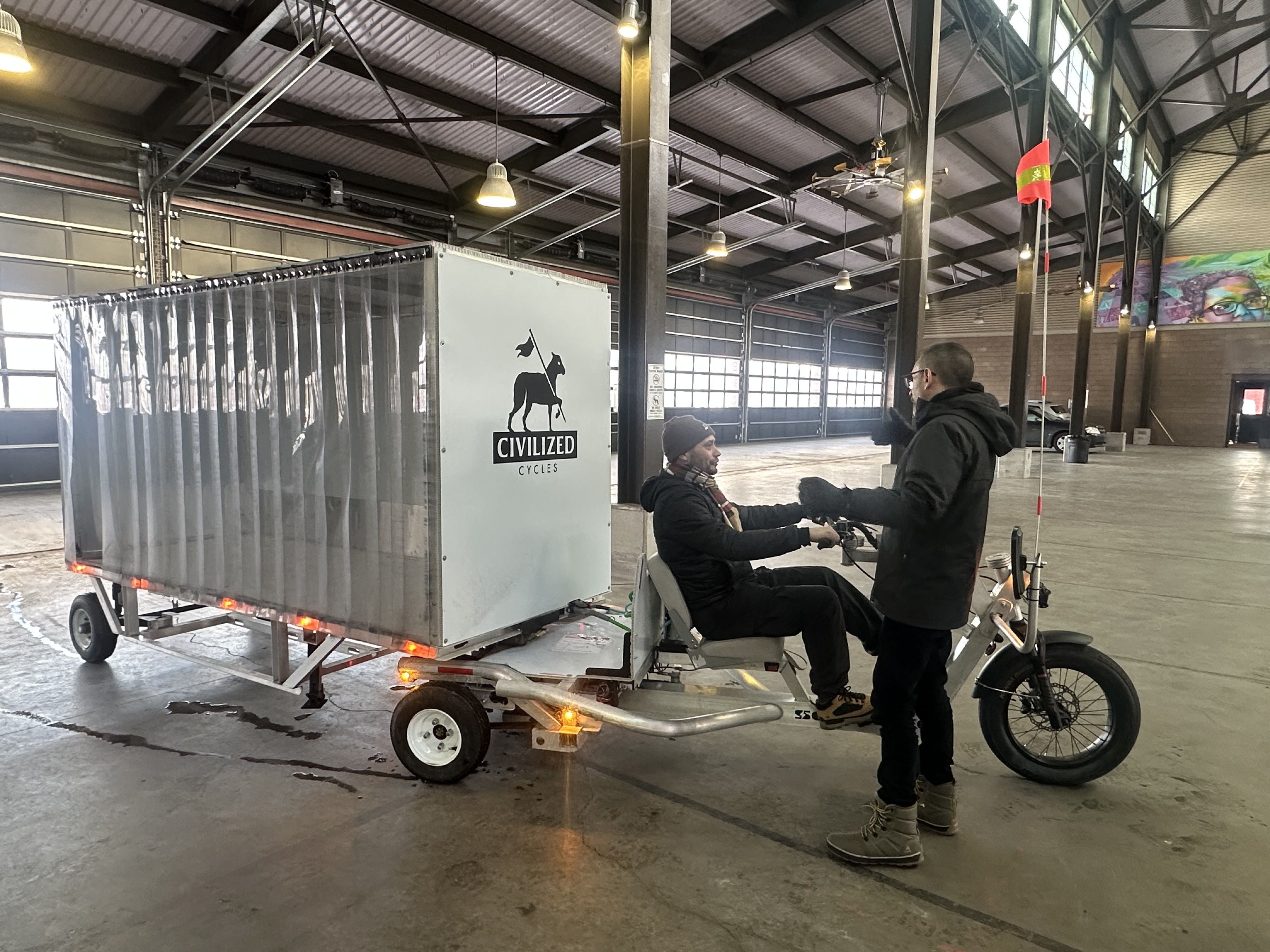 Joe sits on a Civilized Cycle electric bike in the form factor of a semi truck.