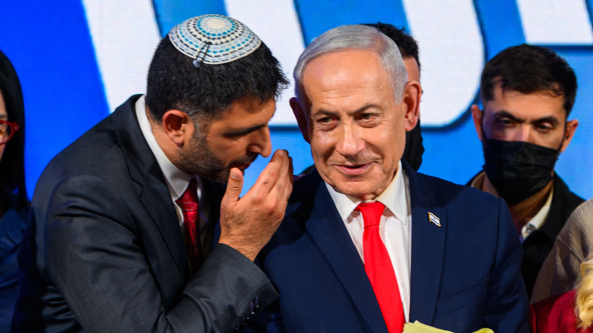 Israel's minister of communications whispers to Israeli Prime Minister Benjamin Netanyahu at an election-night event.