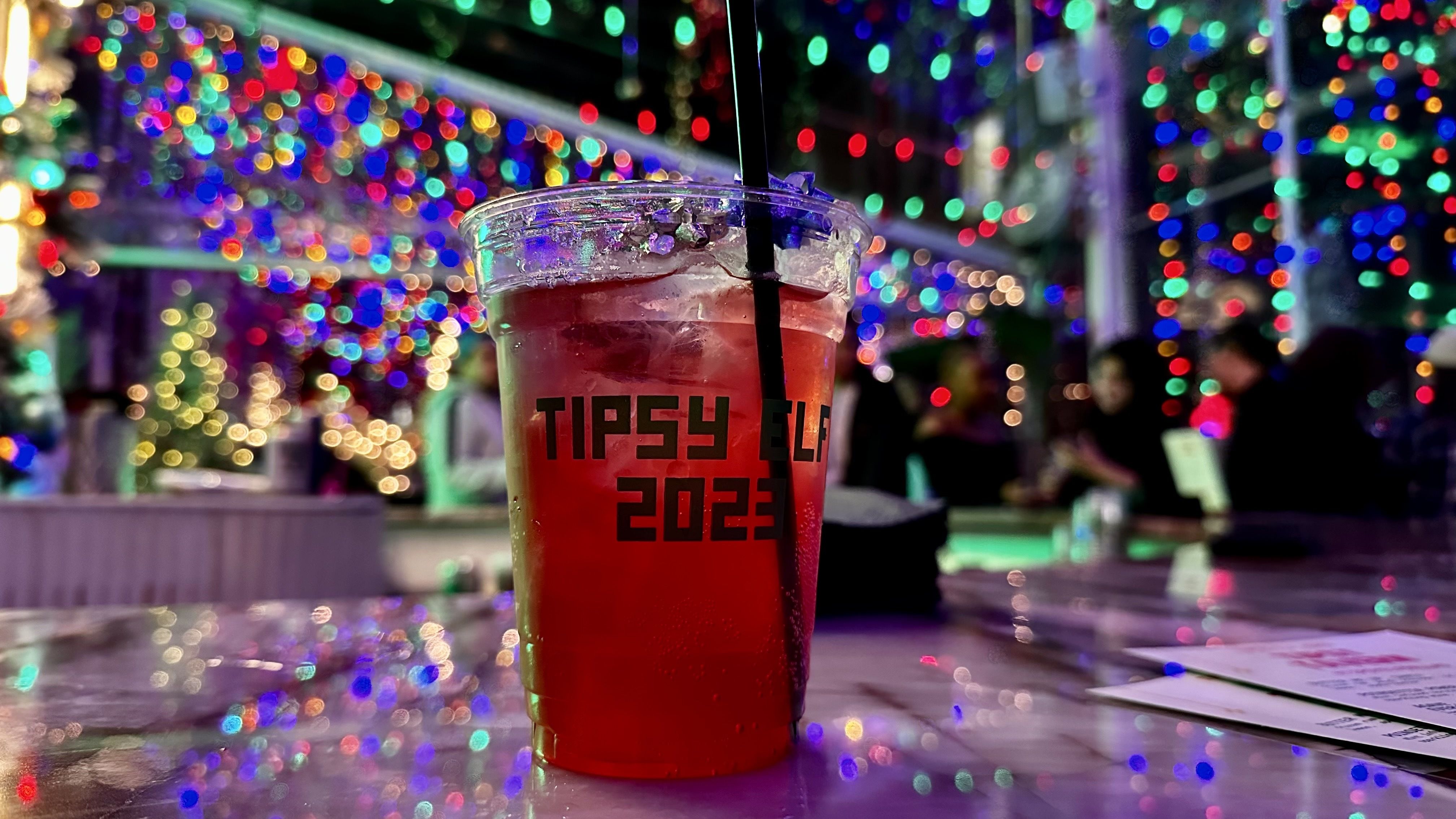 A photo of a cocktail in front of christmas lights