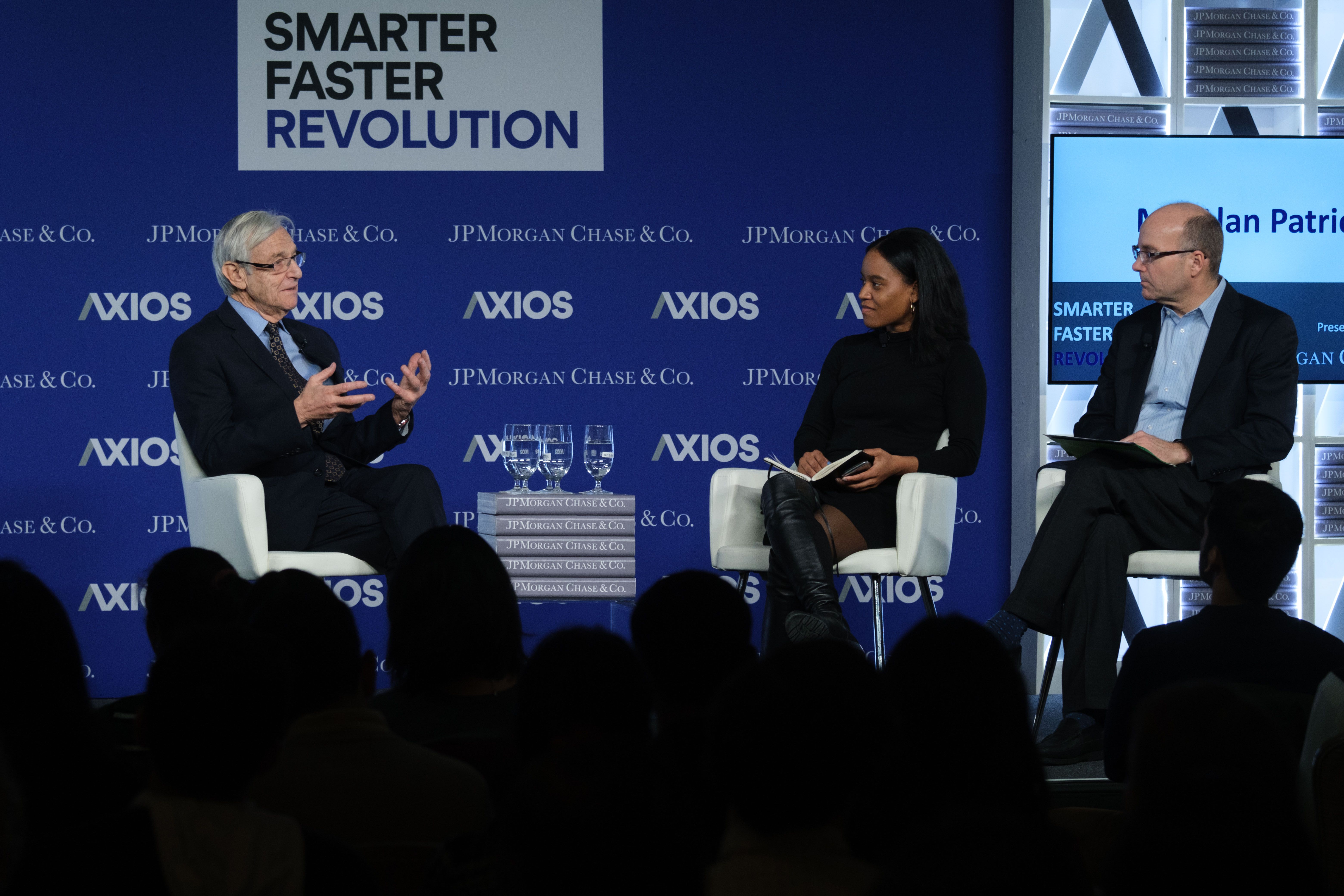 Alan Patricof speaking on stage to Axios' Courtenay Brown and Mike Allen