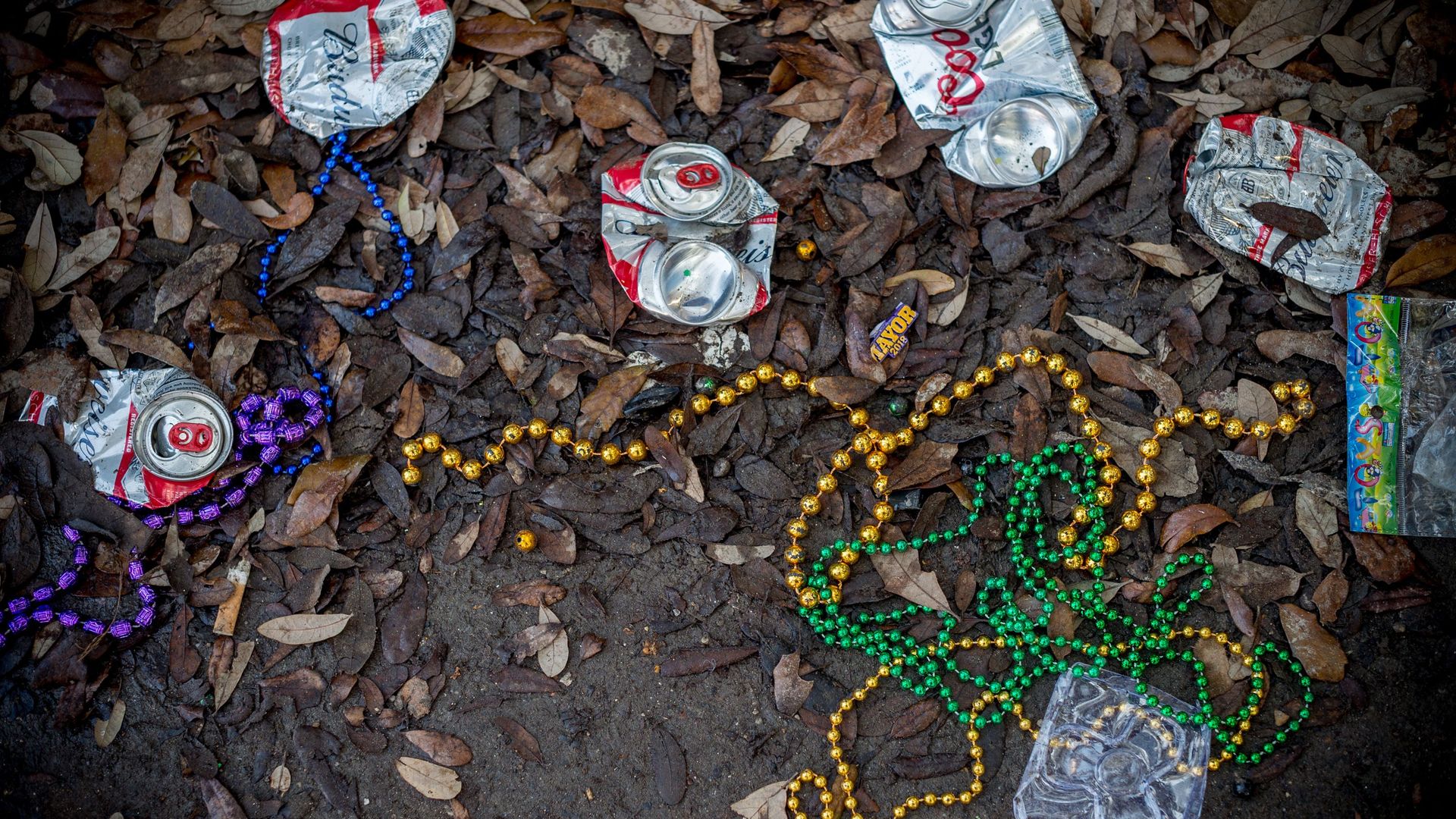 Colorful beaded necklaces and crushed cans littered on the street