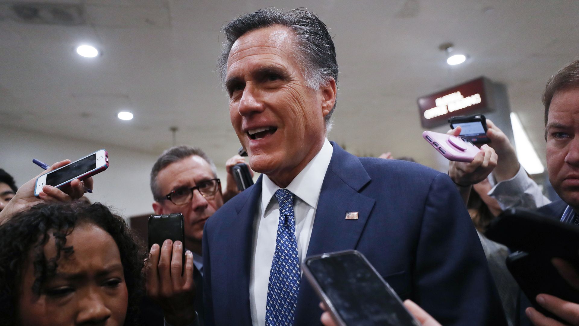 Mitt Romney surrounded by reporters.