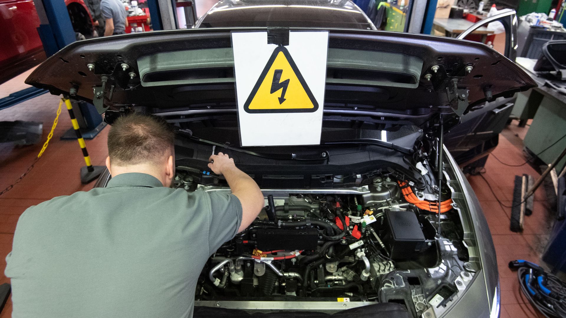 A mechanic maintains an electrically powered vehicle