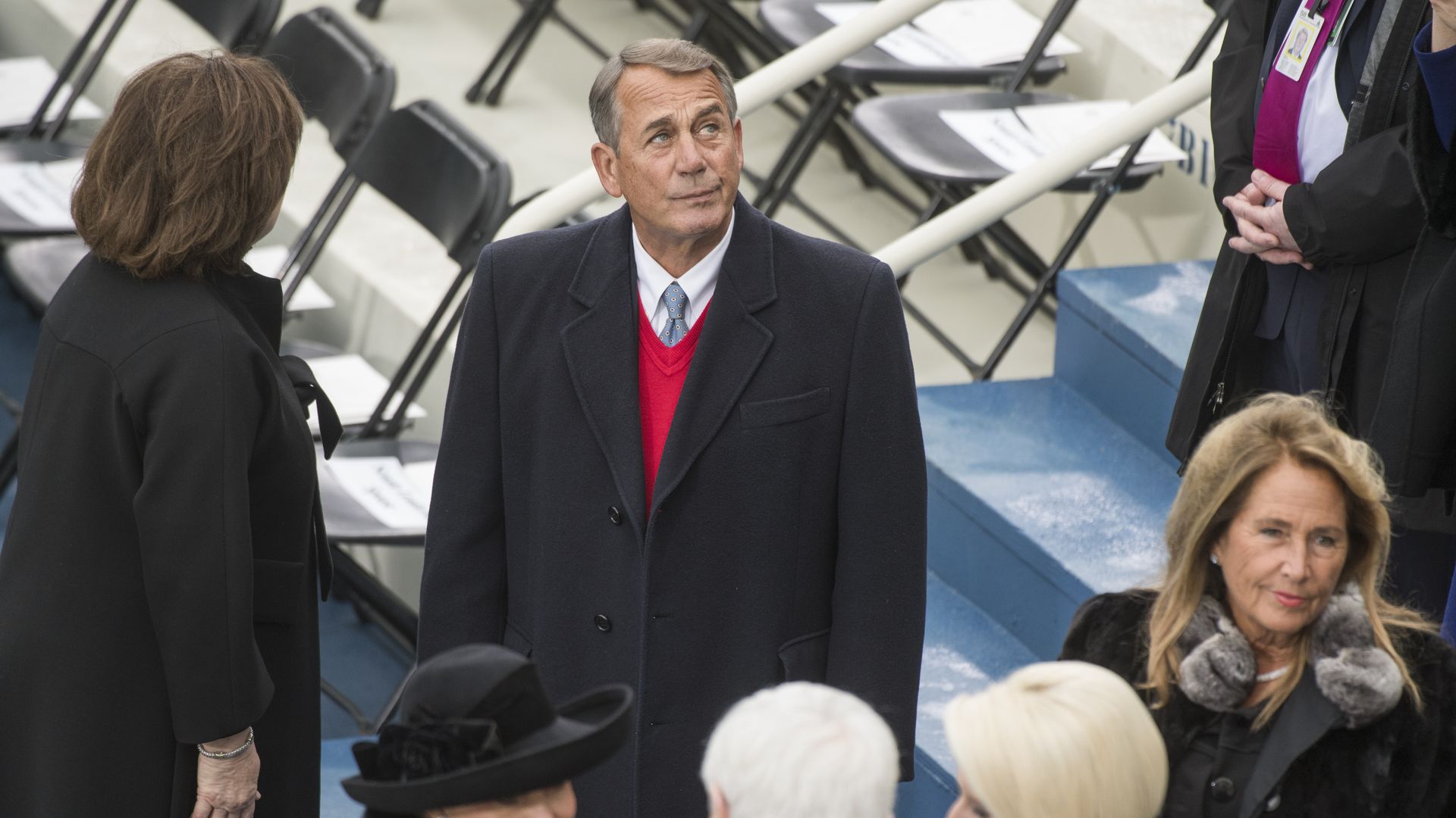 Boehner standing in a coat looking up