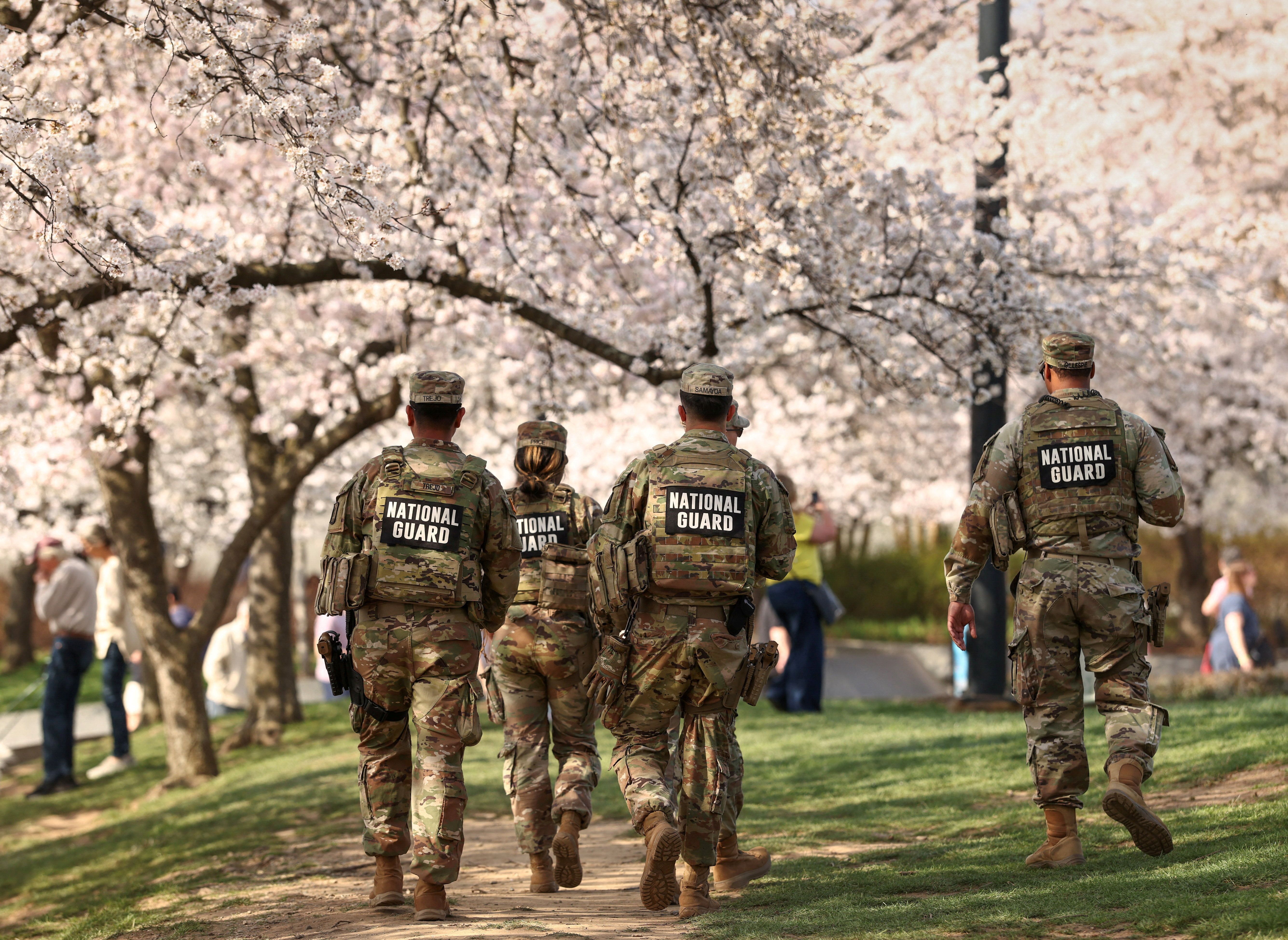 Members of the National Guard patrol amid cherry blossoms along the Tidal Basin in Washington