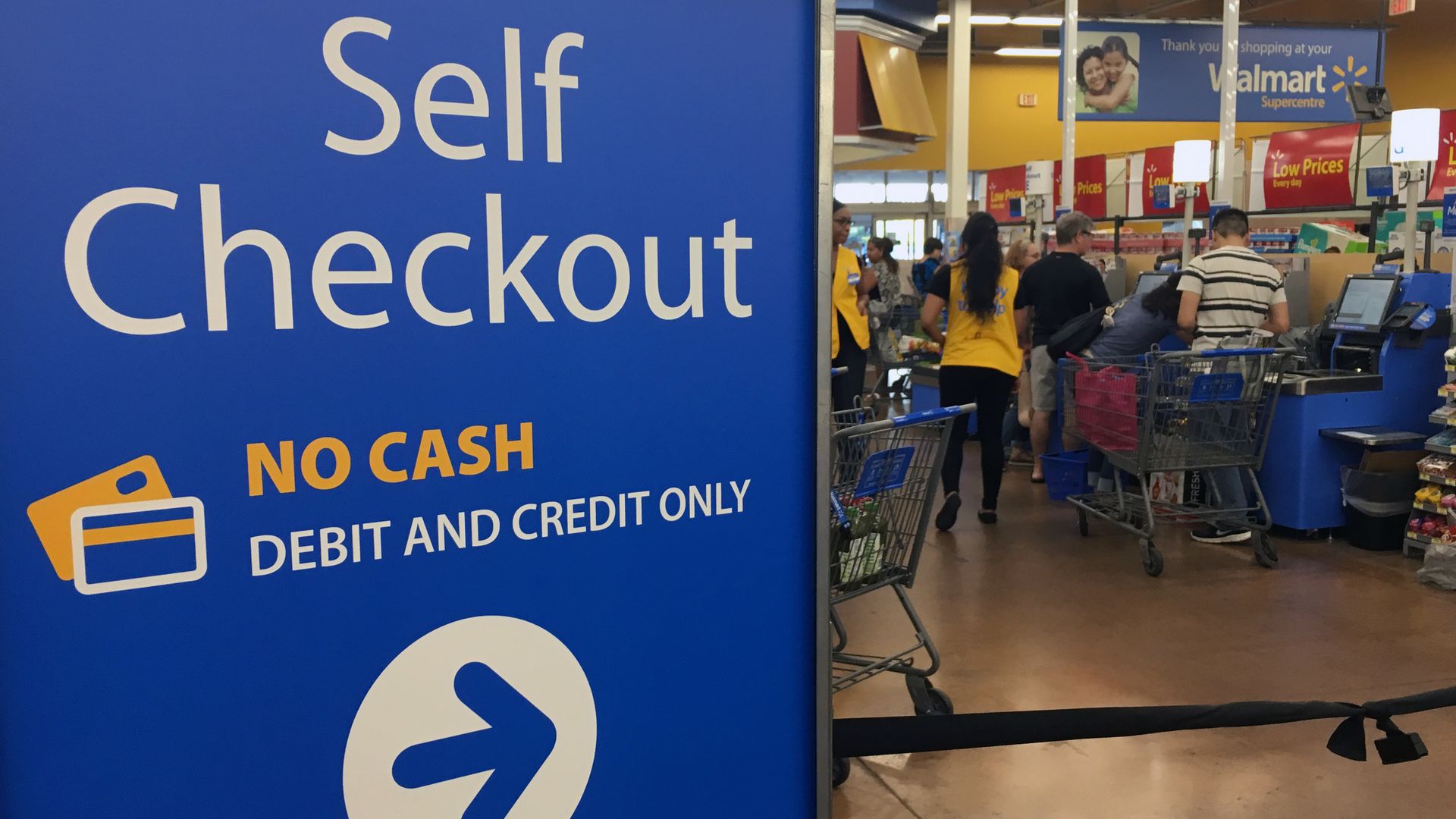A sign in a Walmart pointing customers toward a self checkout