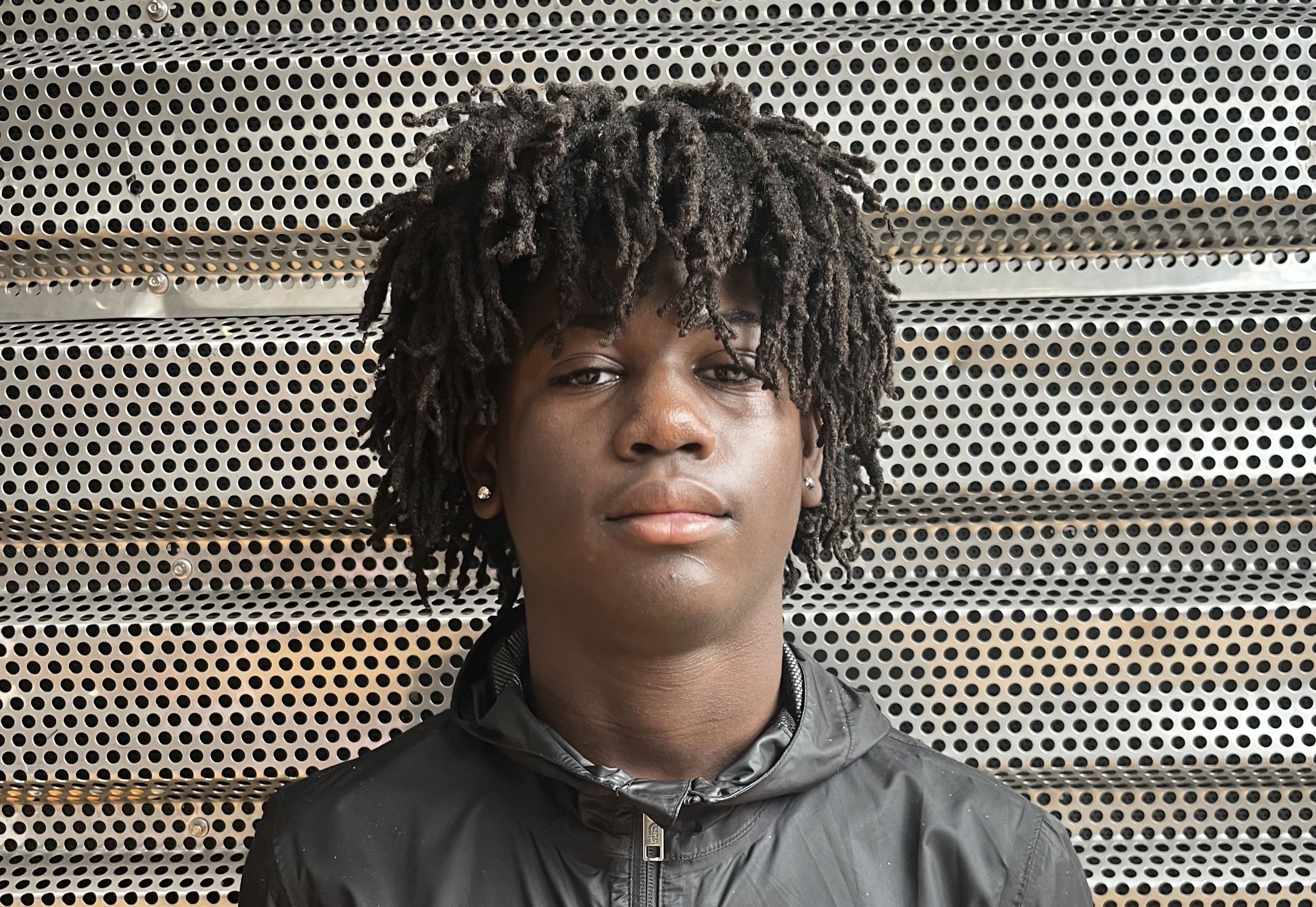 Head shot of a young man with curly hair. 