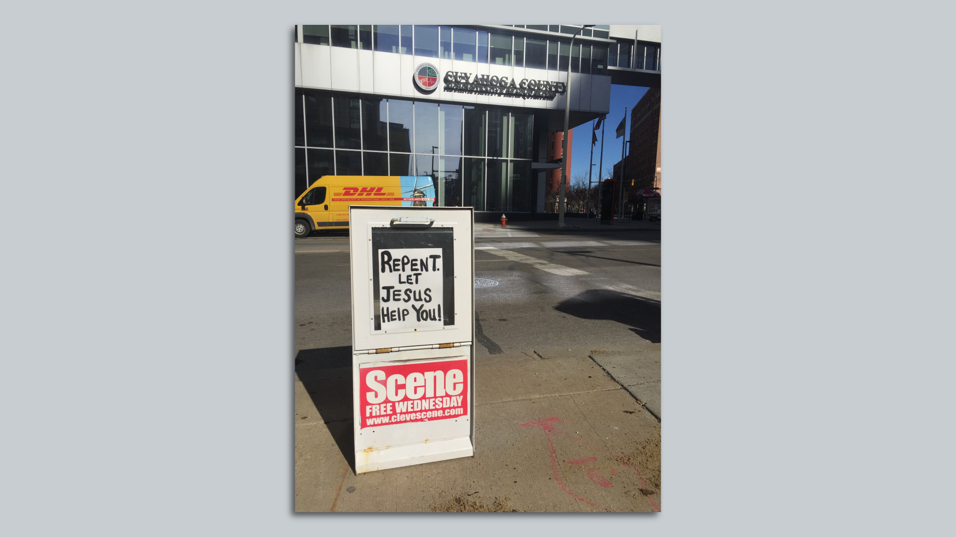 A downtown newspaper box in Cleveland with a paper inserted behind glass reading: Repent! Let Jesus Help You