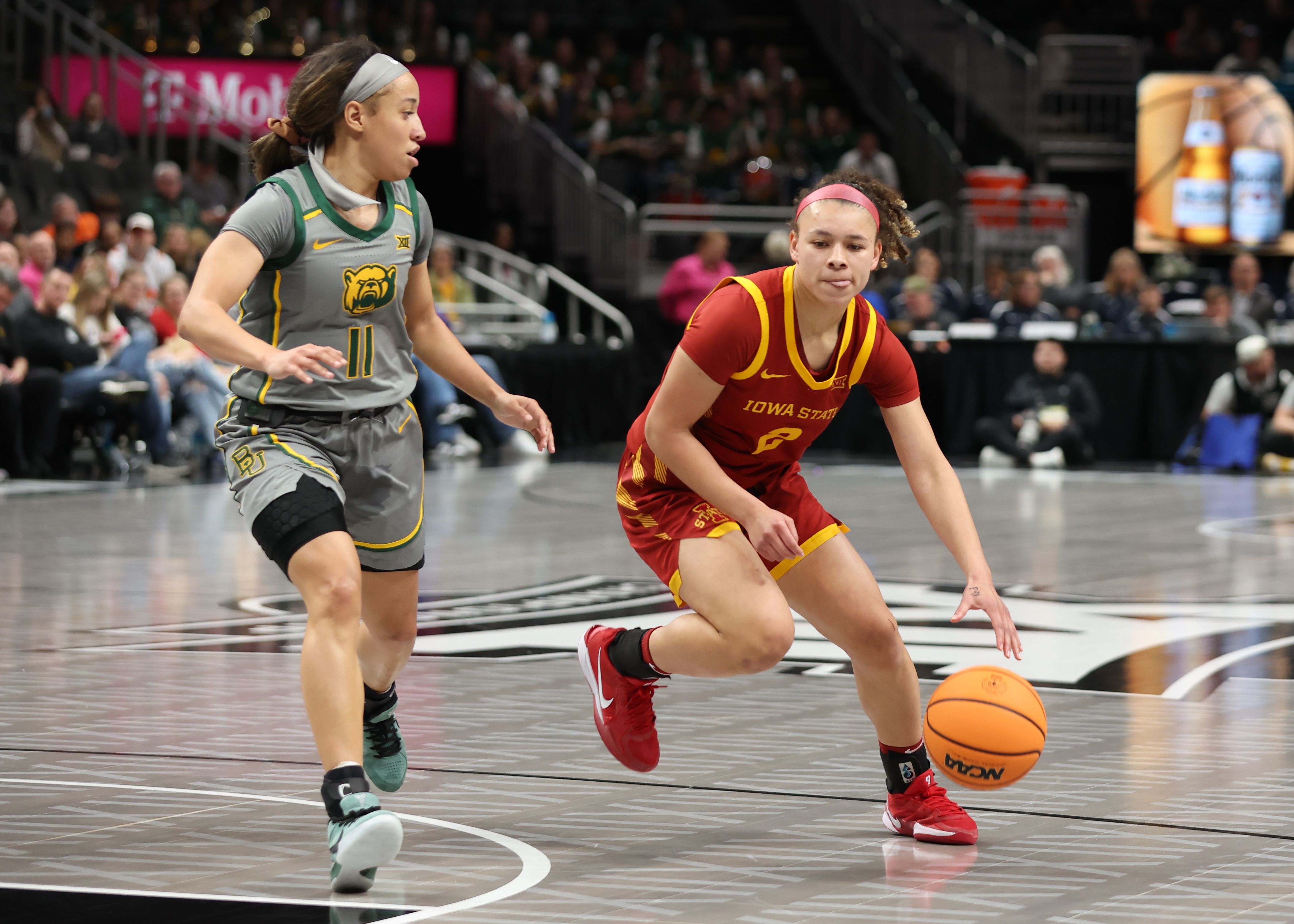 Photo of a woman dribbling a basketball during a game.