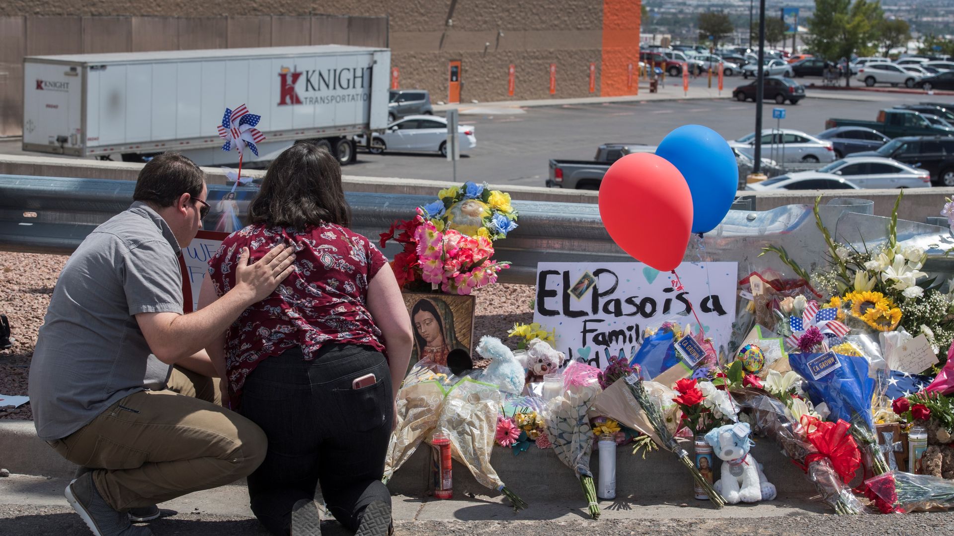 People pray beside a makeshift memorial outside the Cielo Vista Mall Wal-Mart (background) where a shooting left 20 people dead in El Paso, Texas, on August 4, 2019.