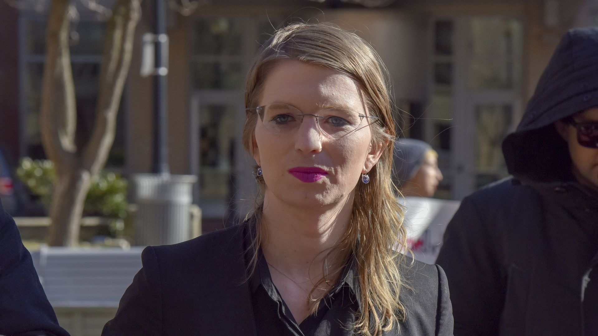 Chelsea Manning pictured outside with two other people.