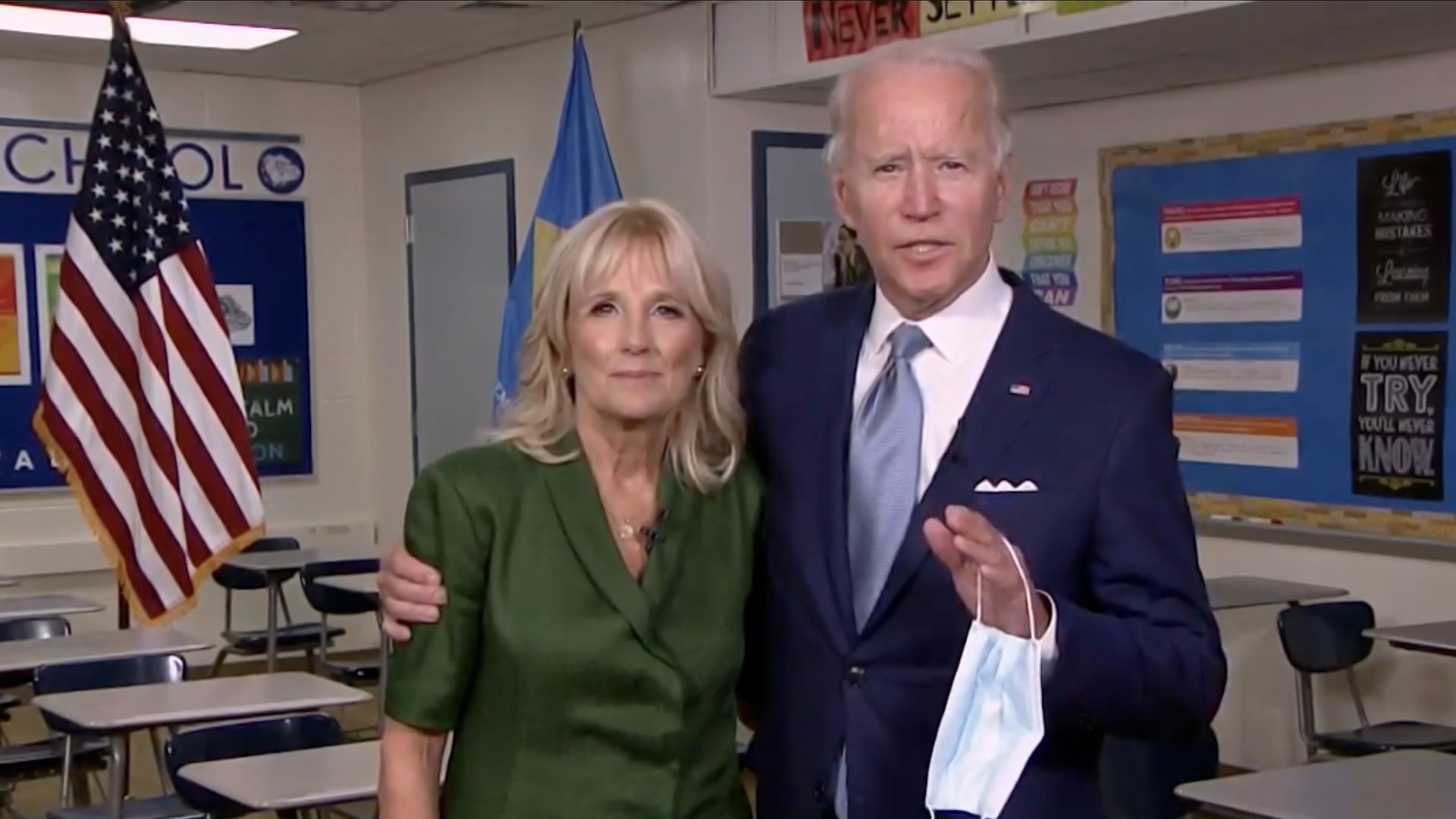 Presumptive Democratic presidential nominee former Vice President Joe Biden holds a mask in his hand as he joins Former U.S. Second Lady Dr. Jill Biden in a classroom
