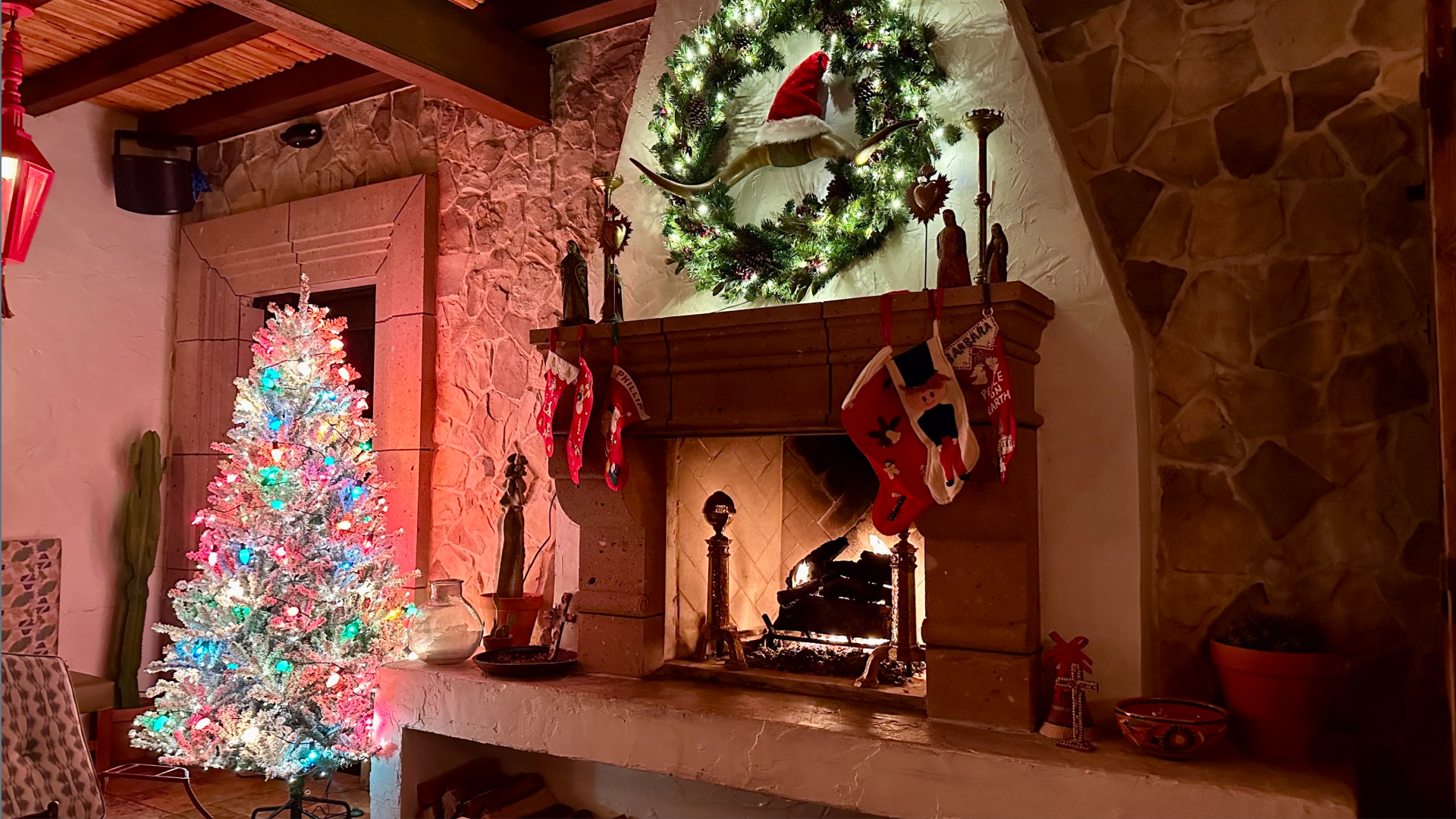 a photo of an interior with a wood-burning fireplace and a white christmas tree nearby