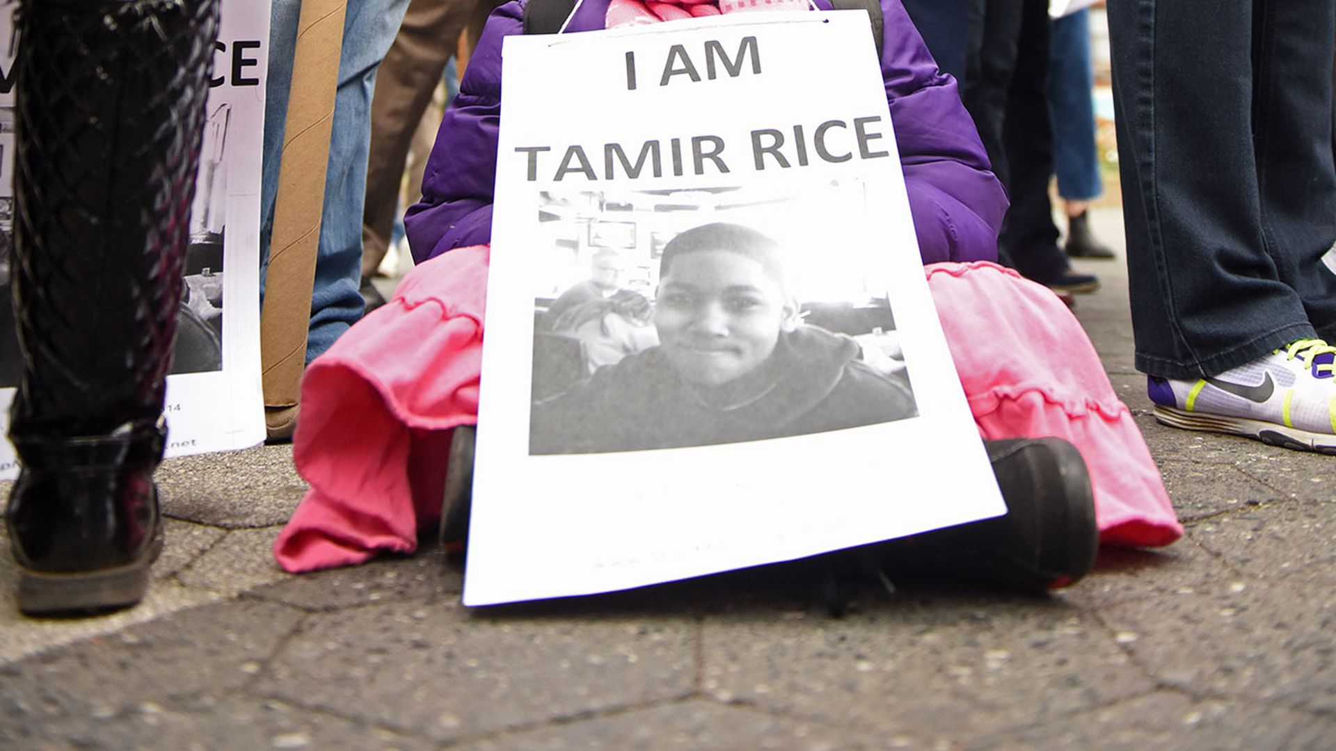 A child holds a sign that says, "I am Tamir Rice."