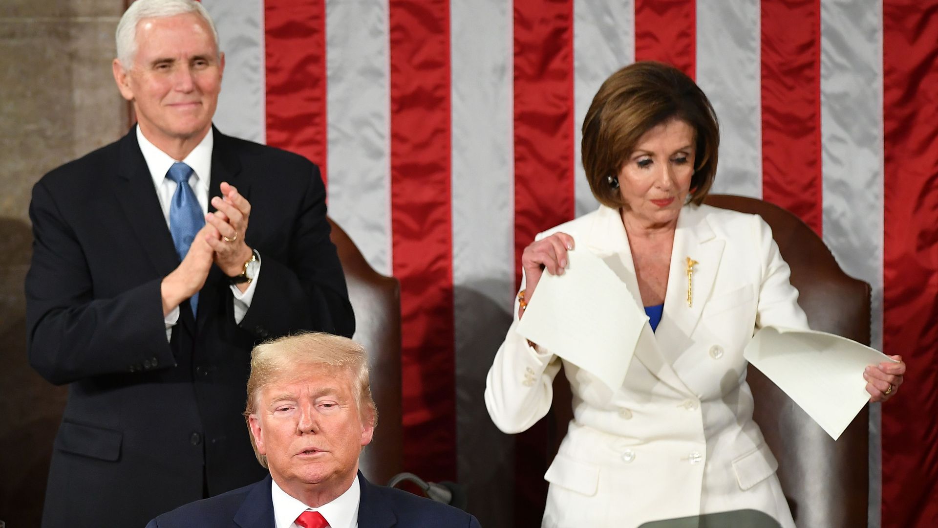 Vice President Mike Pence claps as Speaker of the US House of Representatives Nancy Pelosi appears to rip a copy of US President Donald Trumps speech