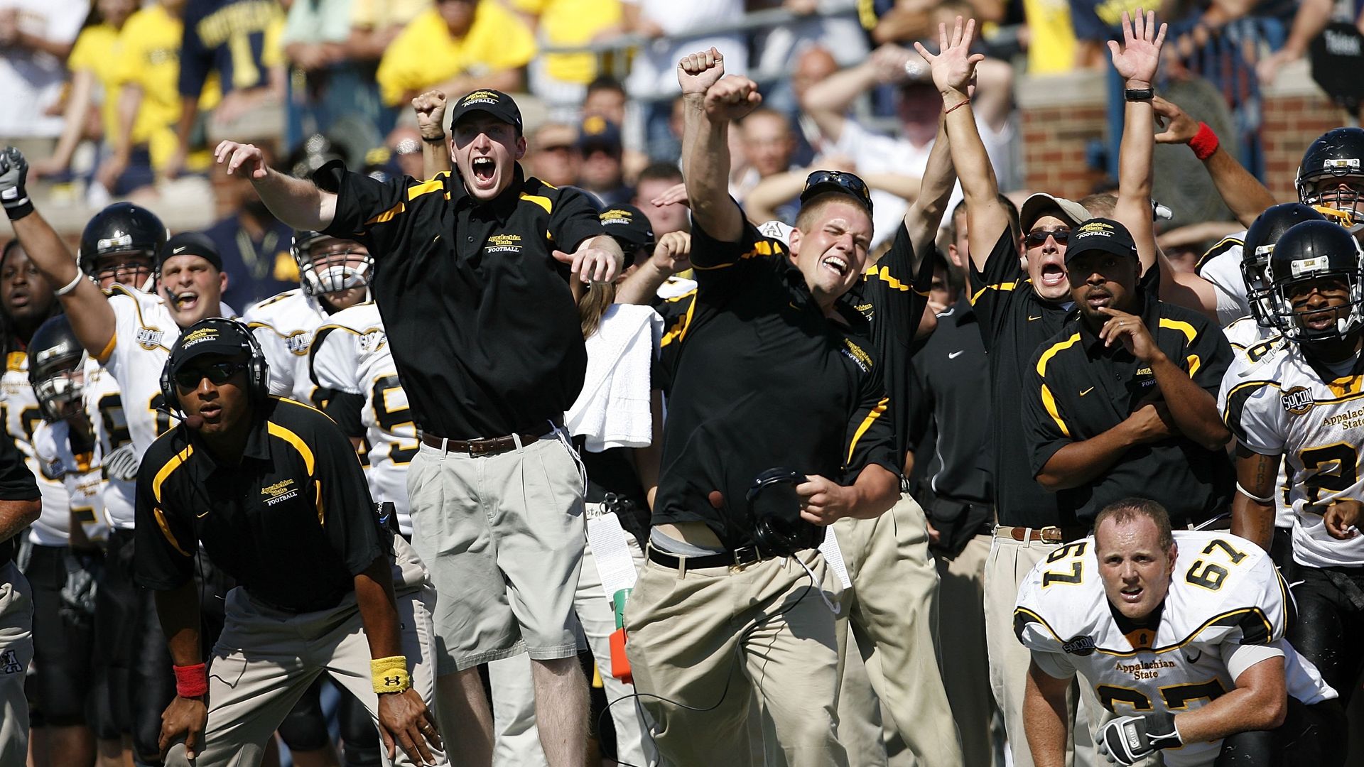 Appalachian State coaches cheer and celebrate on the sidelines