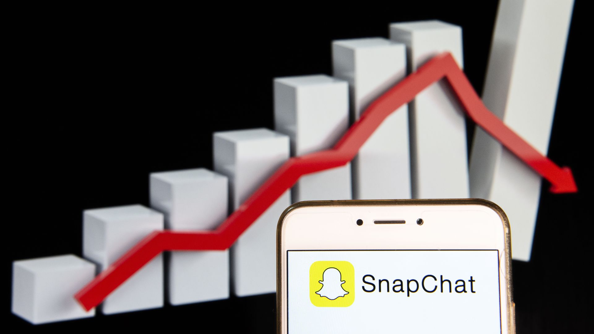 illustration of snap logo in front of declining line graph