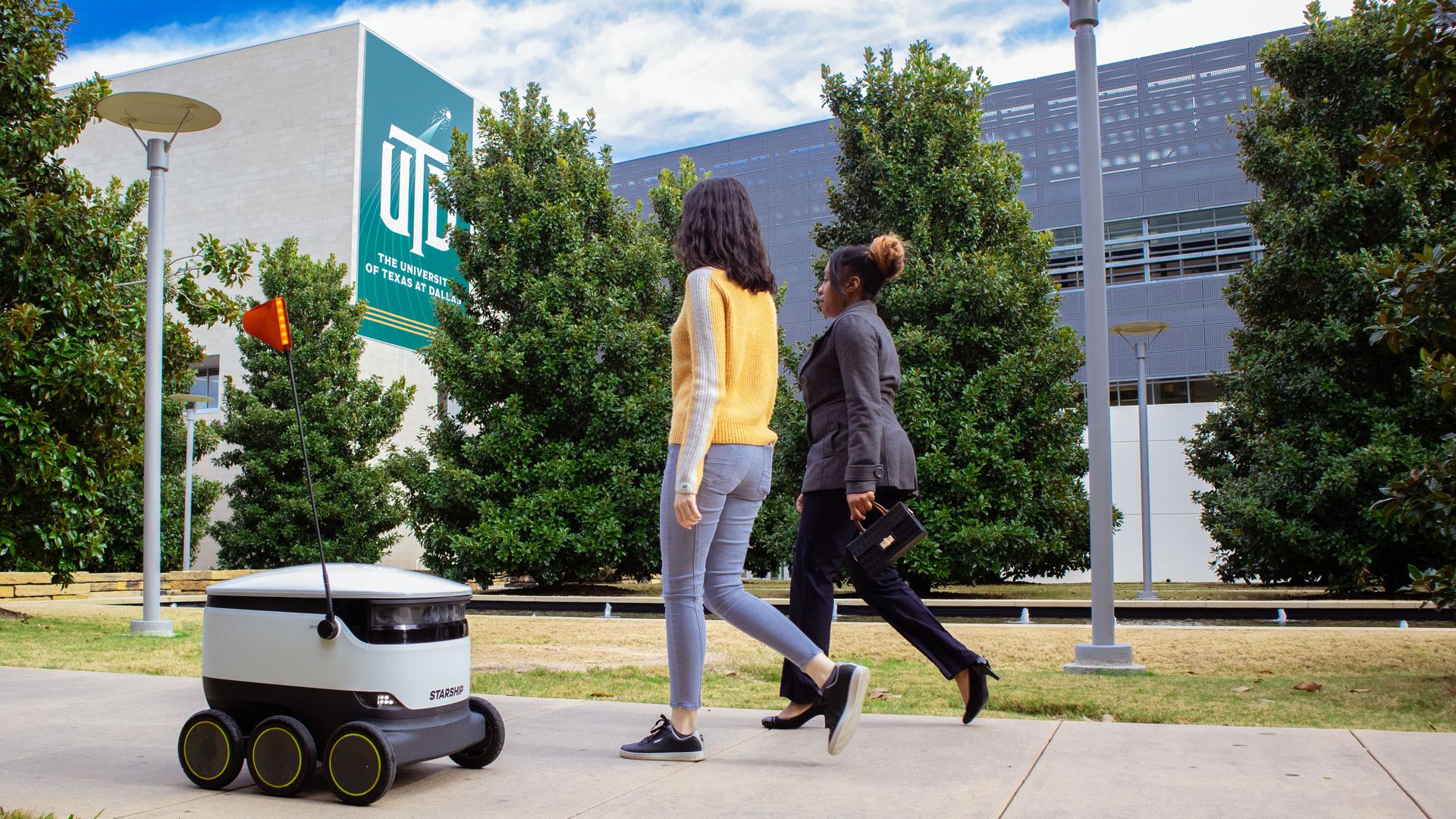 A delivery robot rolls down the sidewalk at the University of Texas campus in Austin.