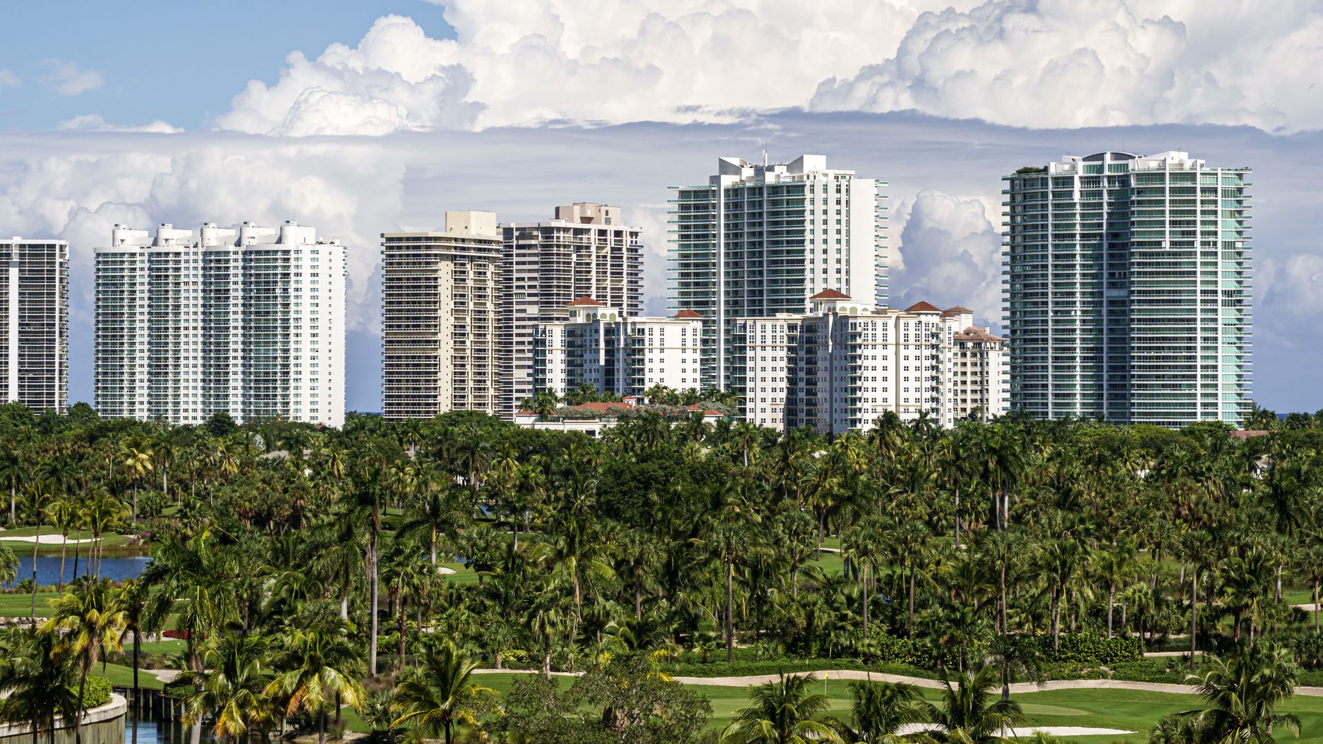 A golf course with buildings in the background. 
