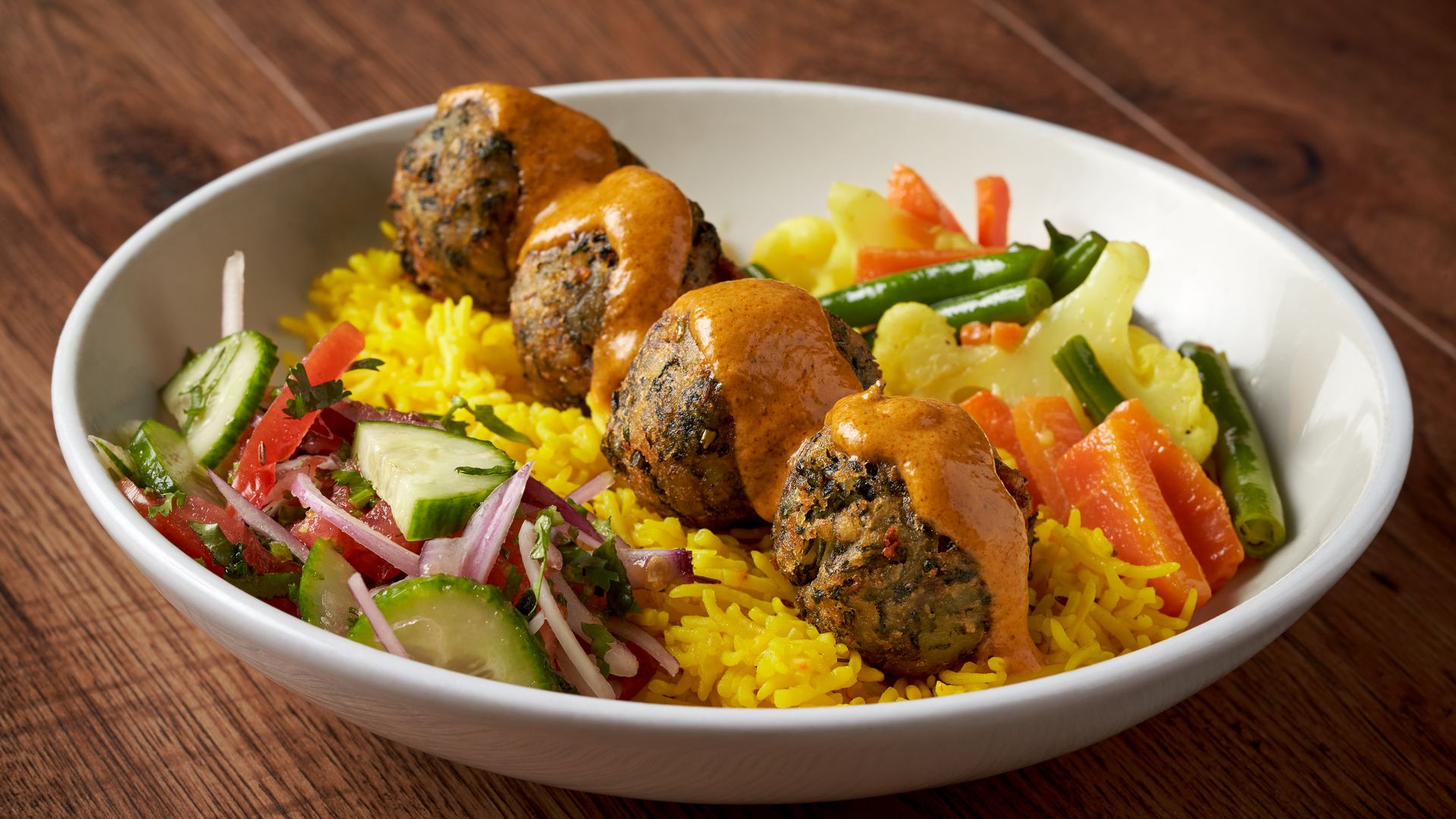 An Indian food bowl with rice and veggies.