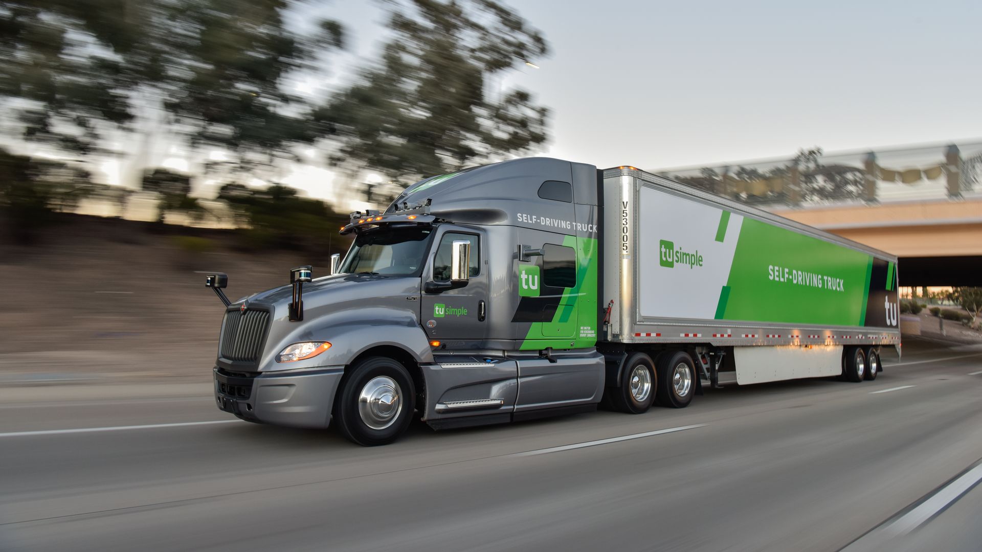 Image of TuSimple semi-truck driving fast under a highway overpass