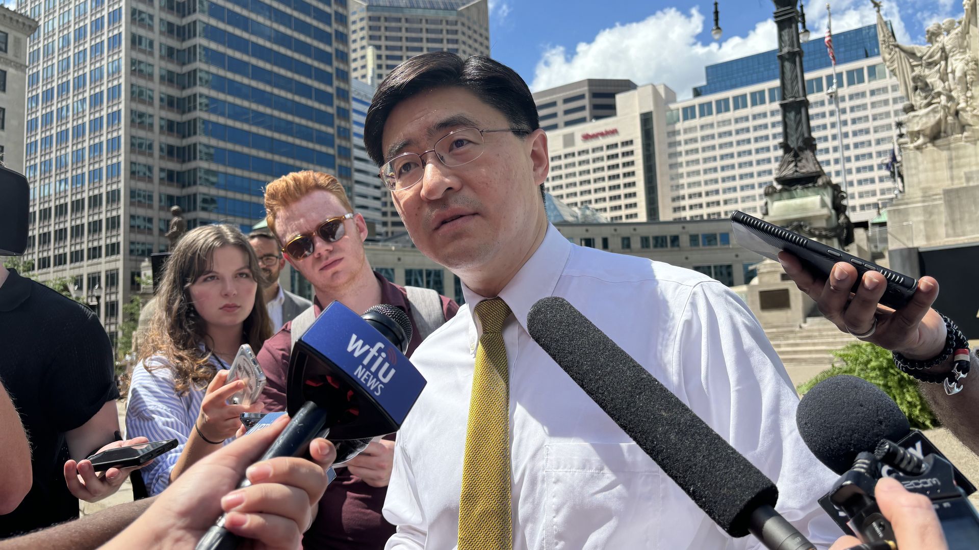 Purdue President Mung Chiang surrounded by microphones