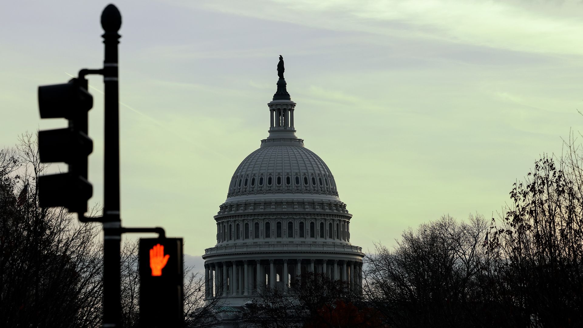 A photo of the U.S. Capitol's dome, with a stoplight in front of it.