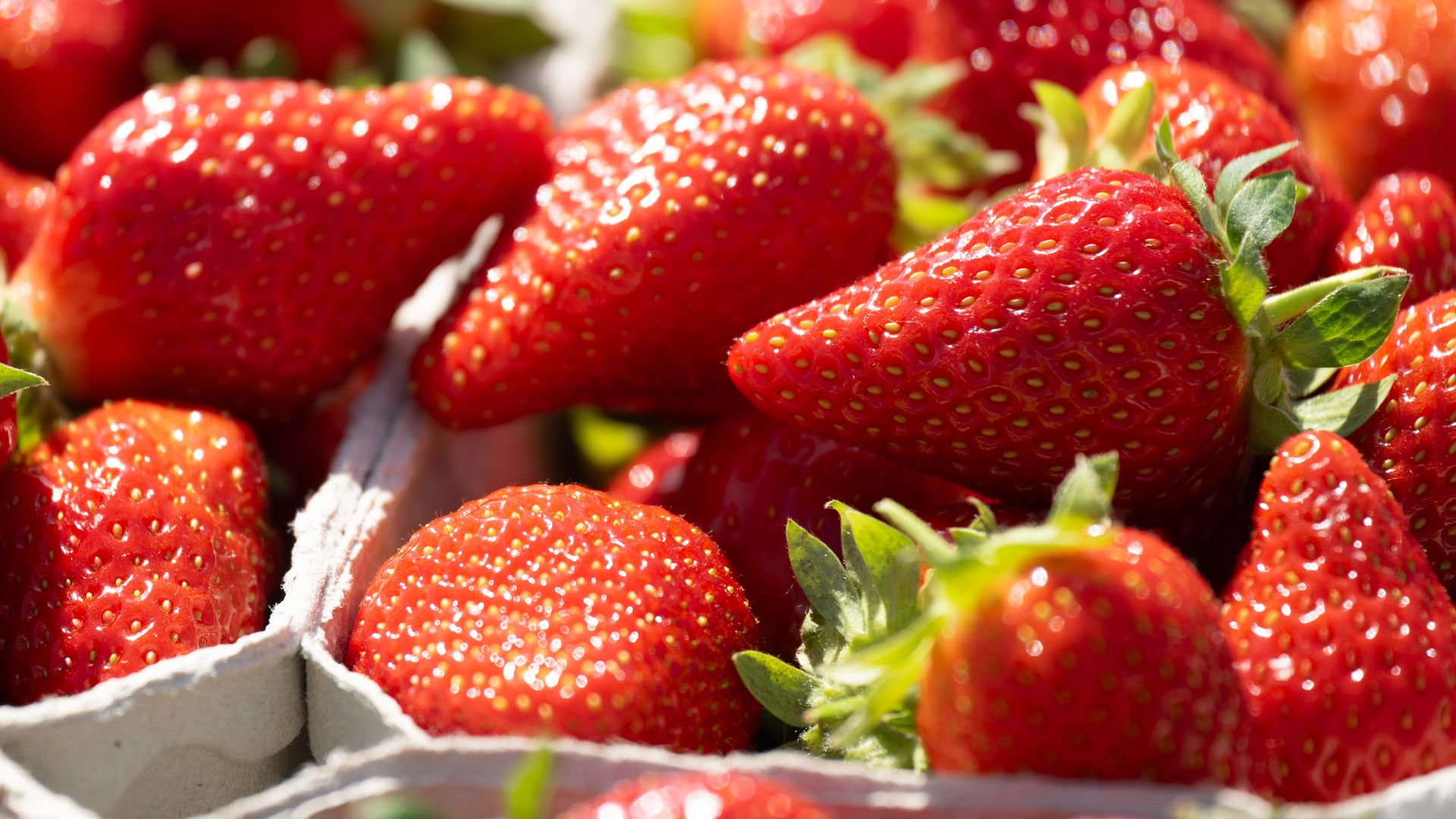 A photo of very ripe strawberries in cartons