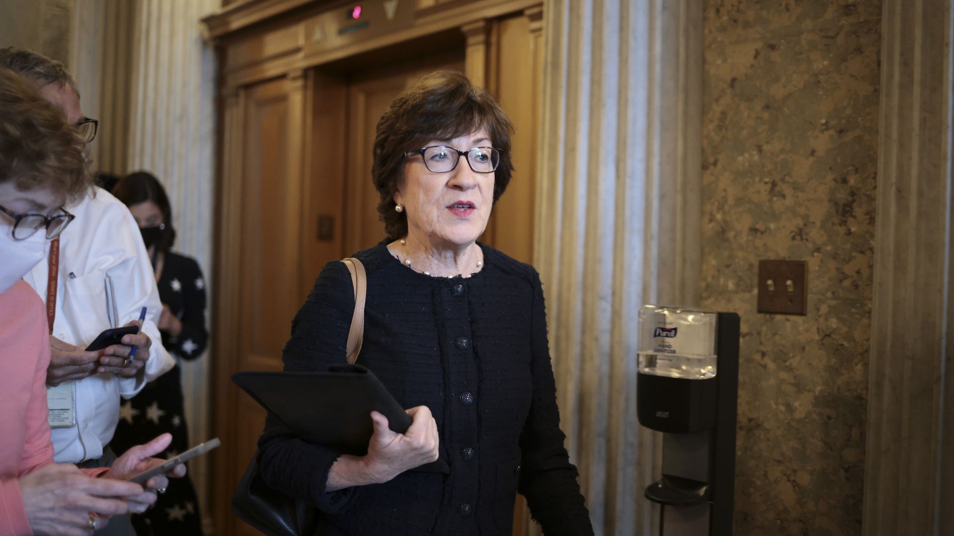 Photo of Susan Collins walking in the Senate building halls