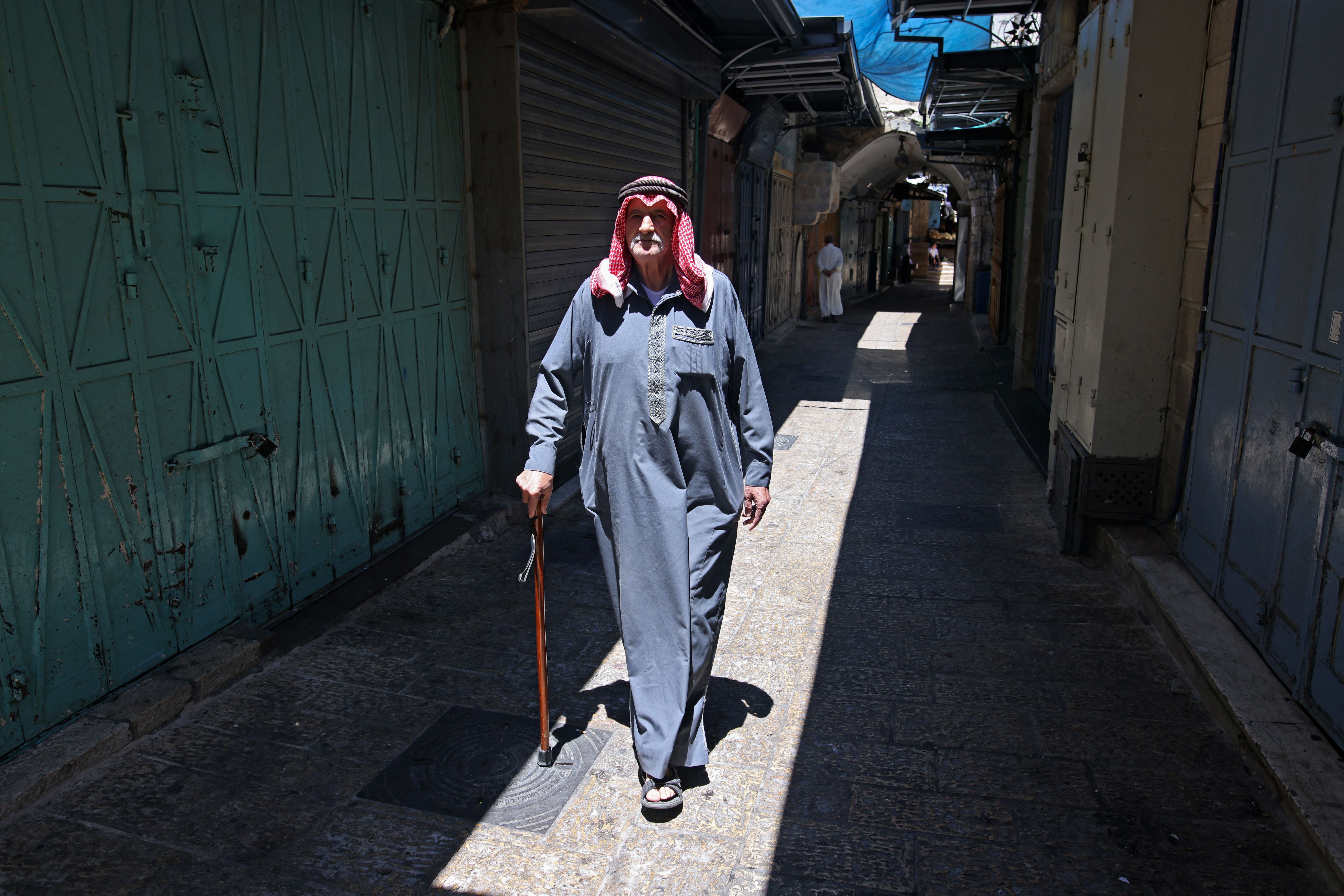 A Palestinian man walks past shuttered stores in East Jerusalem. Photo: Ahmad Gharabli/AFP via Getty Images