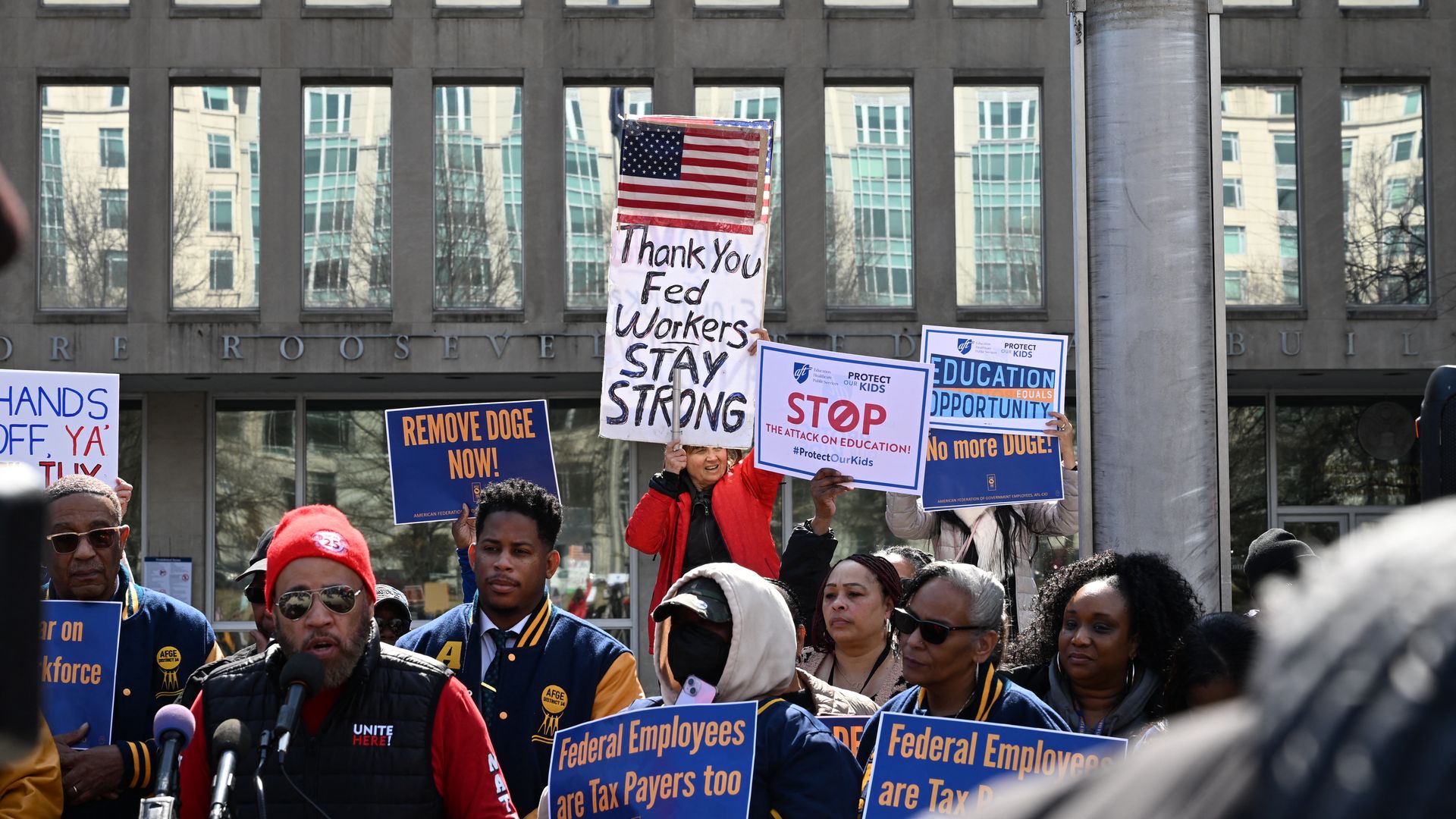 Protesters hold signs in solidarity with the American Federation of Government Employees of District 14 at a rally in support of federal workers at the Office of Personnel Management in Washington, DC, March 4, 2025. 
