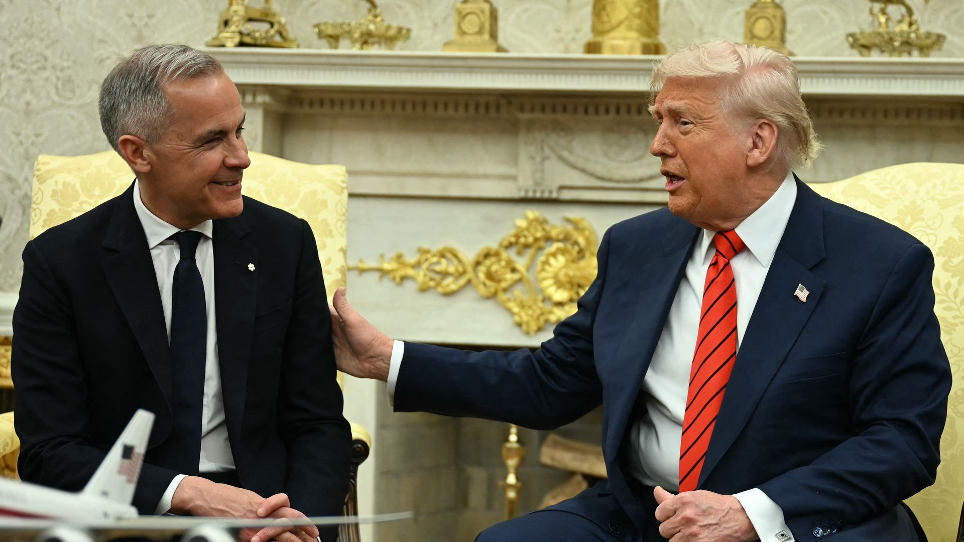 Mark Carney and Donald Trump sit at chairs in the Oval Office 