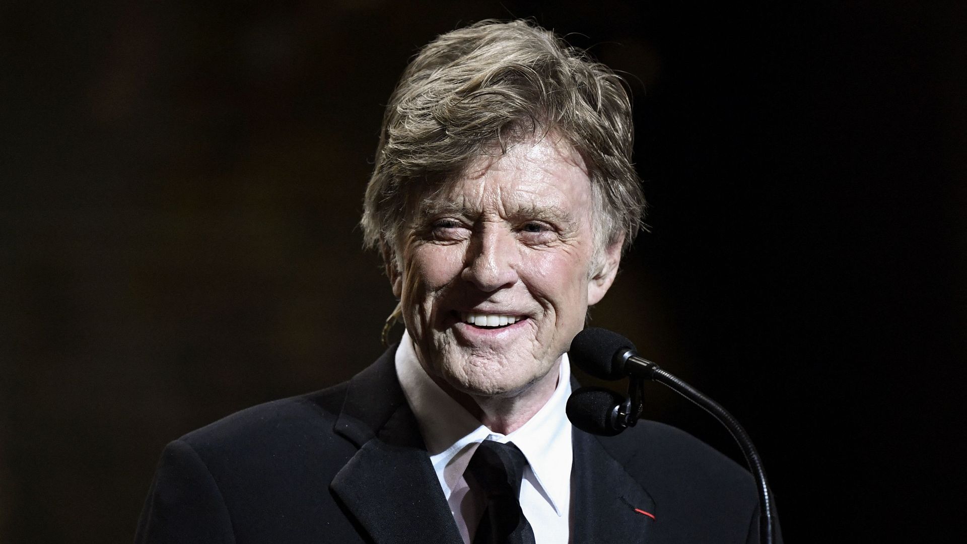Robert Redford stands on stage holding the César honorary award during the 2019 ceremony in Paris.