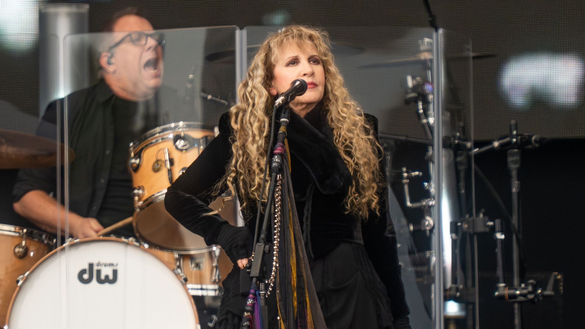 A woman standing at a microphone on stage.