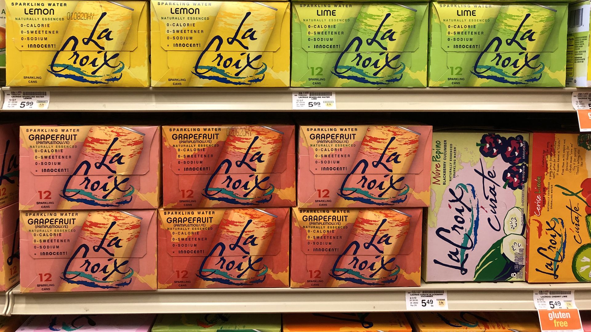 Multi-colored boxes of LaCroix sit on aisle shelves in a grocery store.