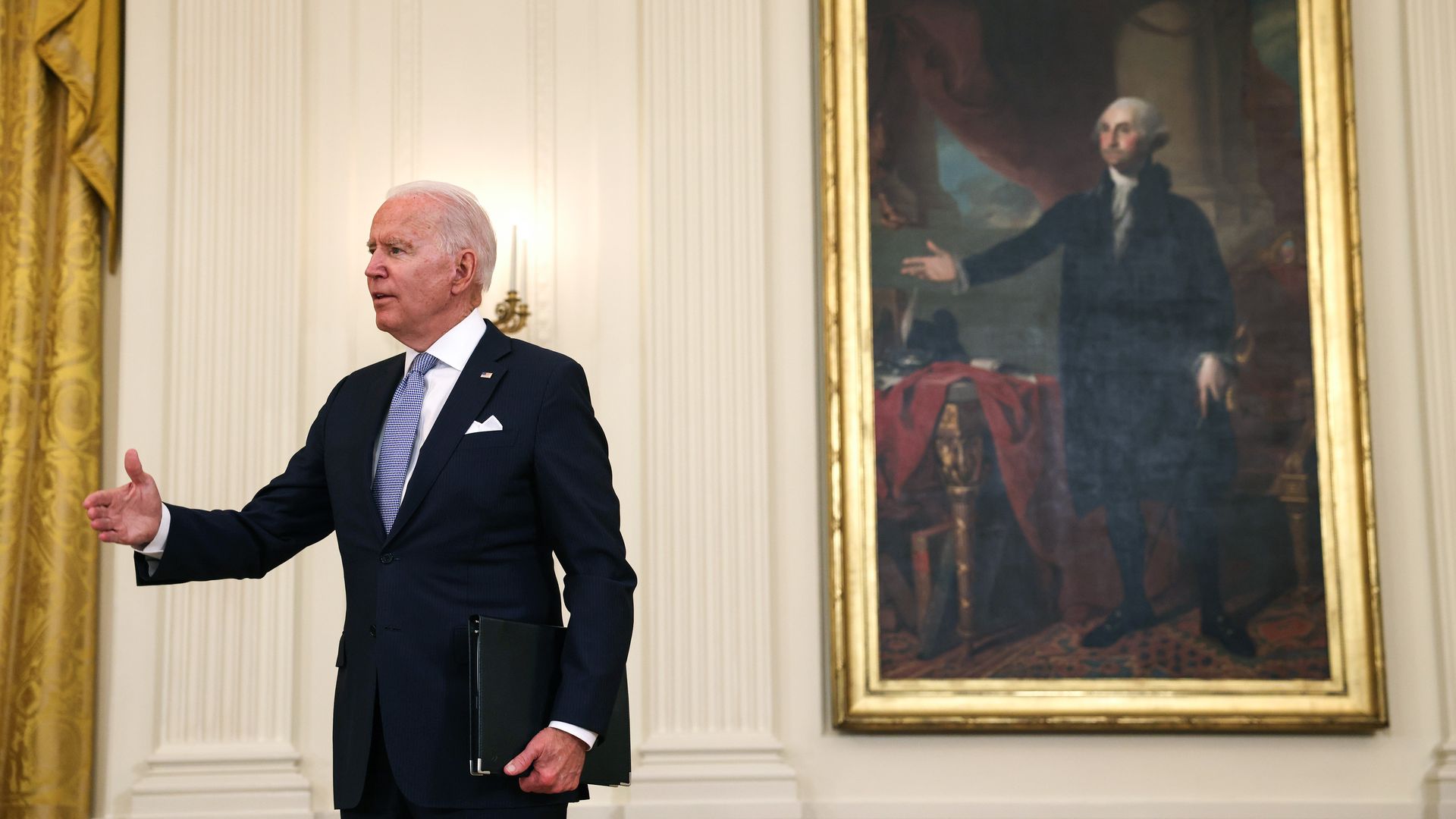 President Biden is seen gesturing in front of a portrait of George Washington in a similar pose.