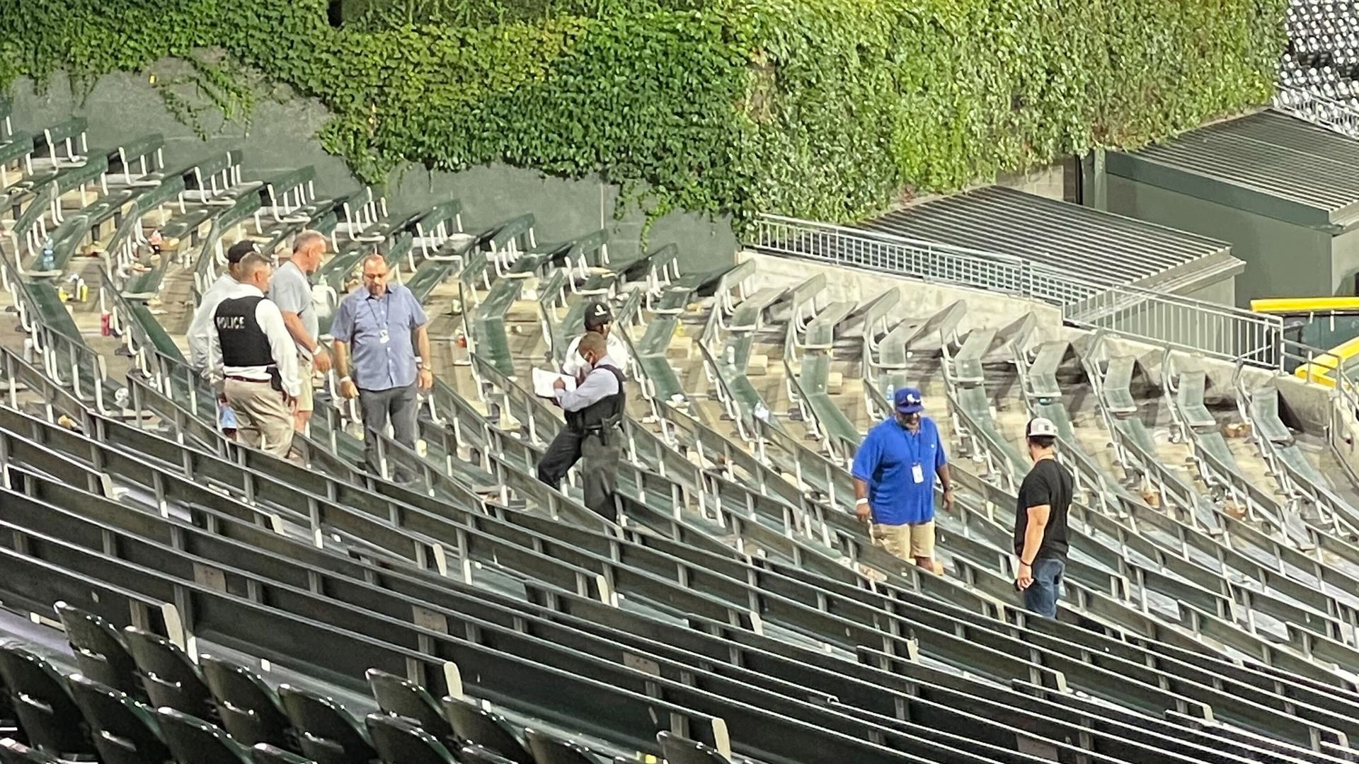 Photo of people looking at stadium bleachers after a baseball game 