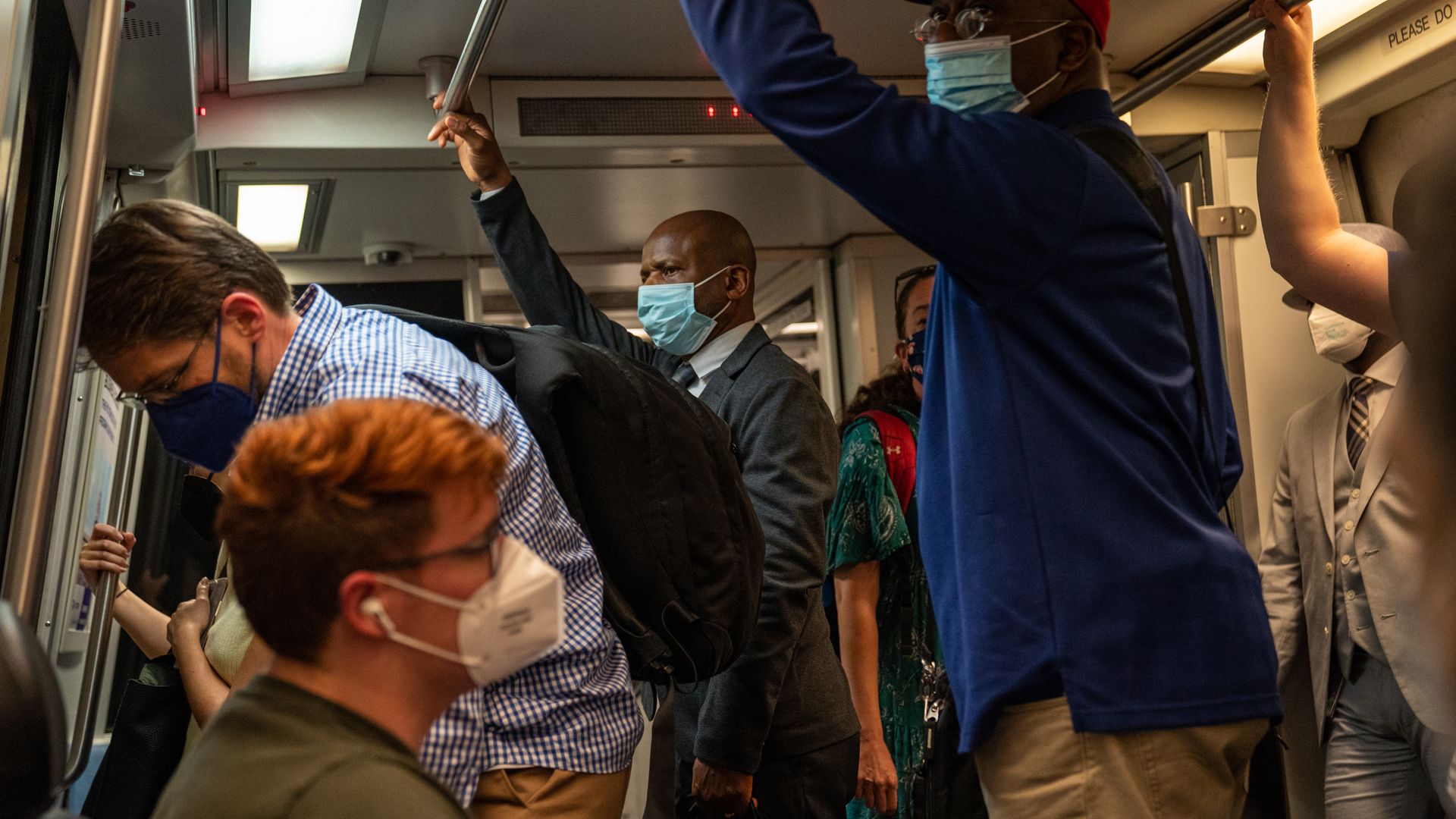 Commuters wearing masks travel on the Metro.