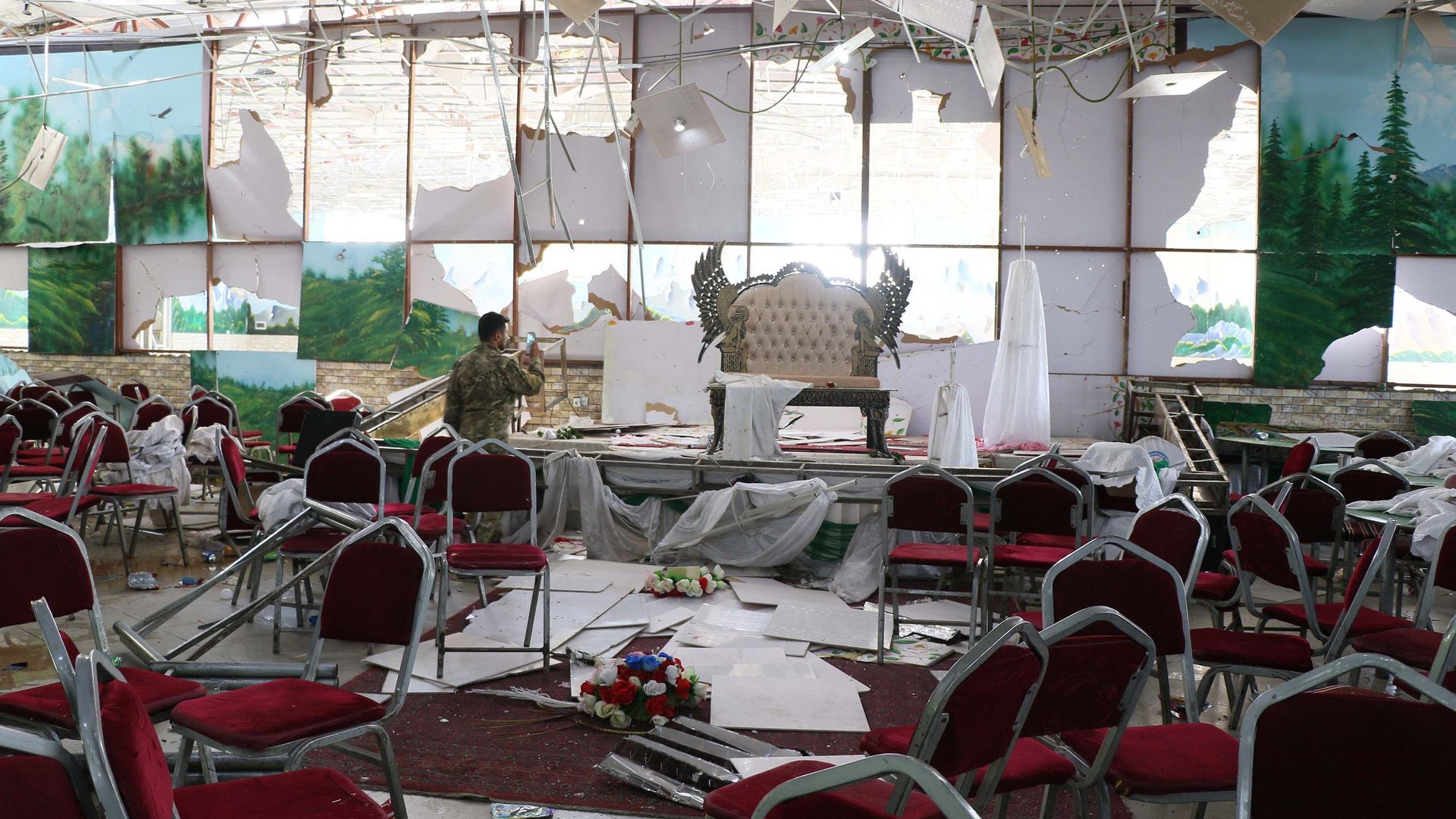 Afghan security officials inspect the scene after an overnight suicide bomb blast that targeted a wedding reception in Kabul, Afghanistan