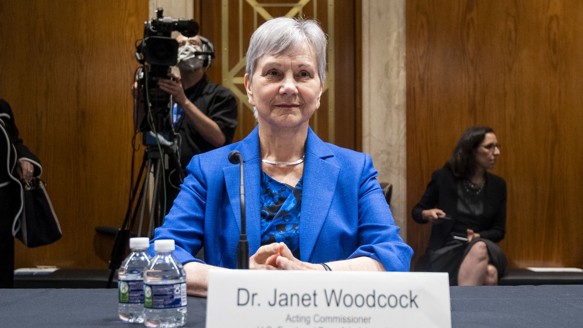FDA Acting Commissioner Janet Woodcock wears a blue blazer and sits at a table in Congress.