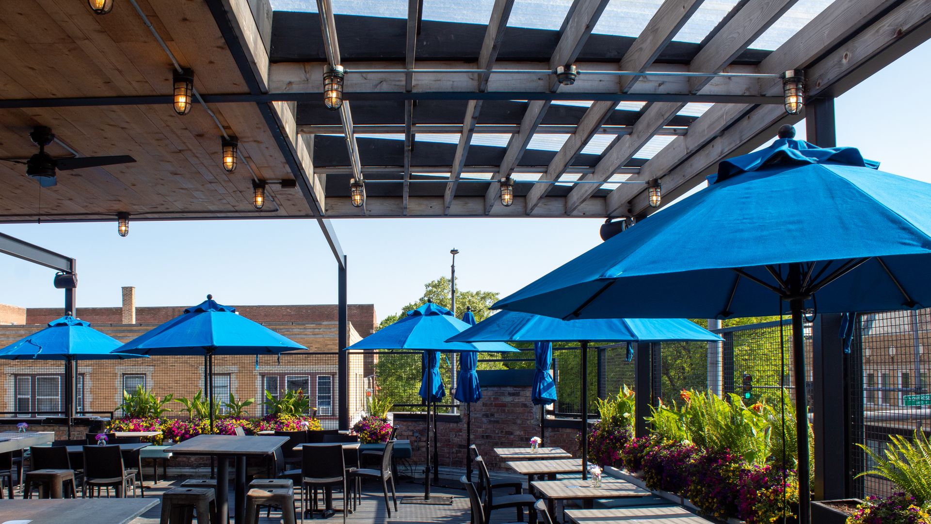 Rooftop patio with tables with blue umbrellas.