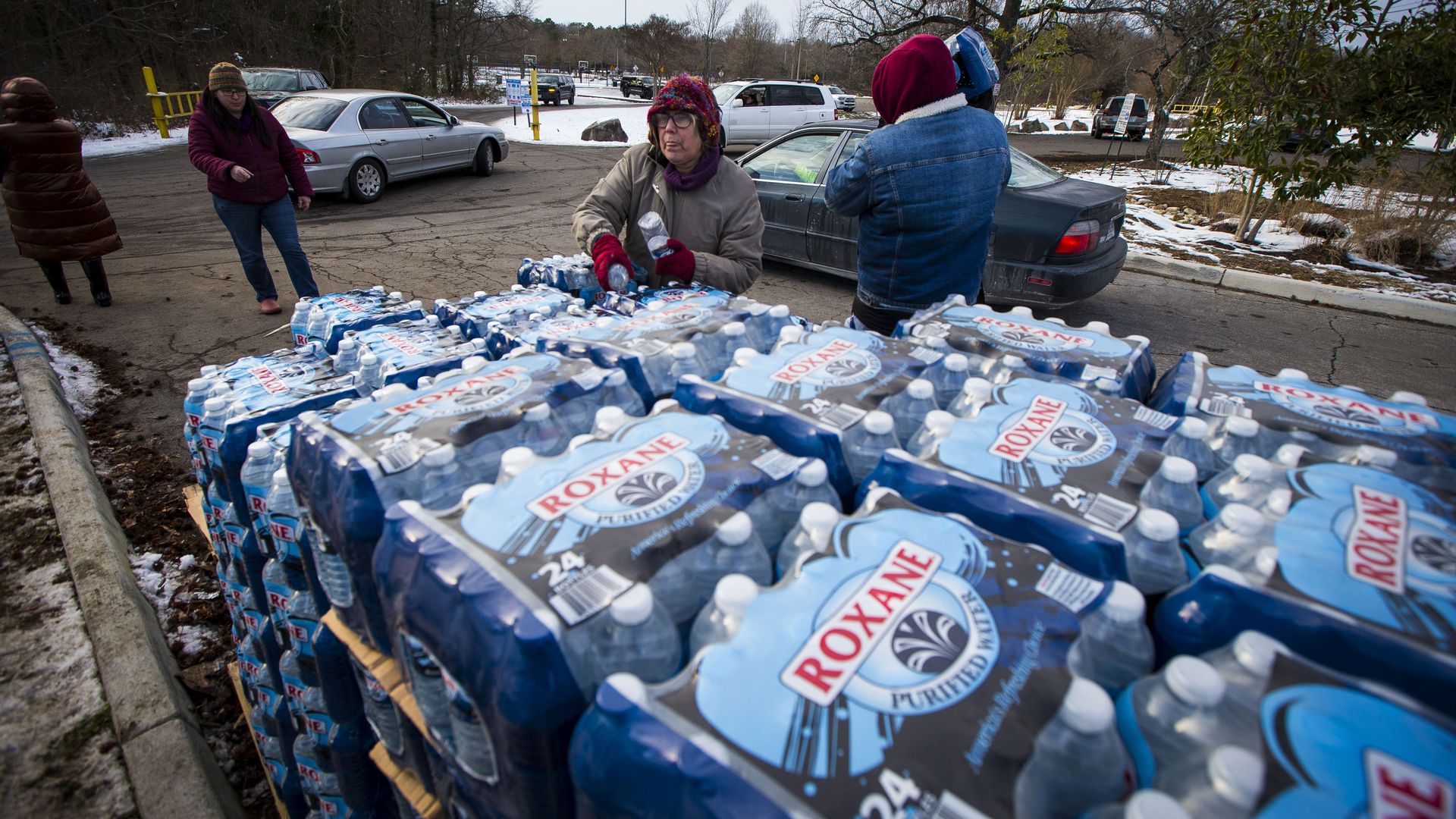 people handing out crates of water